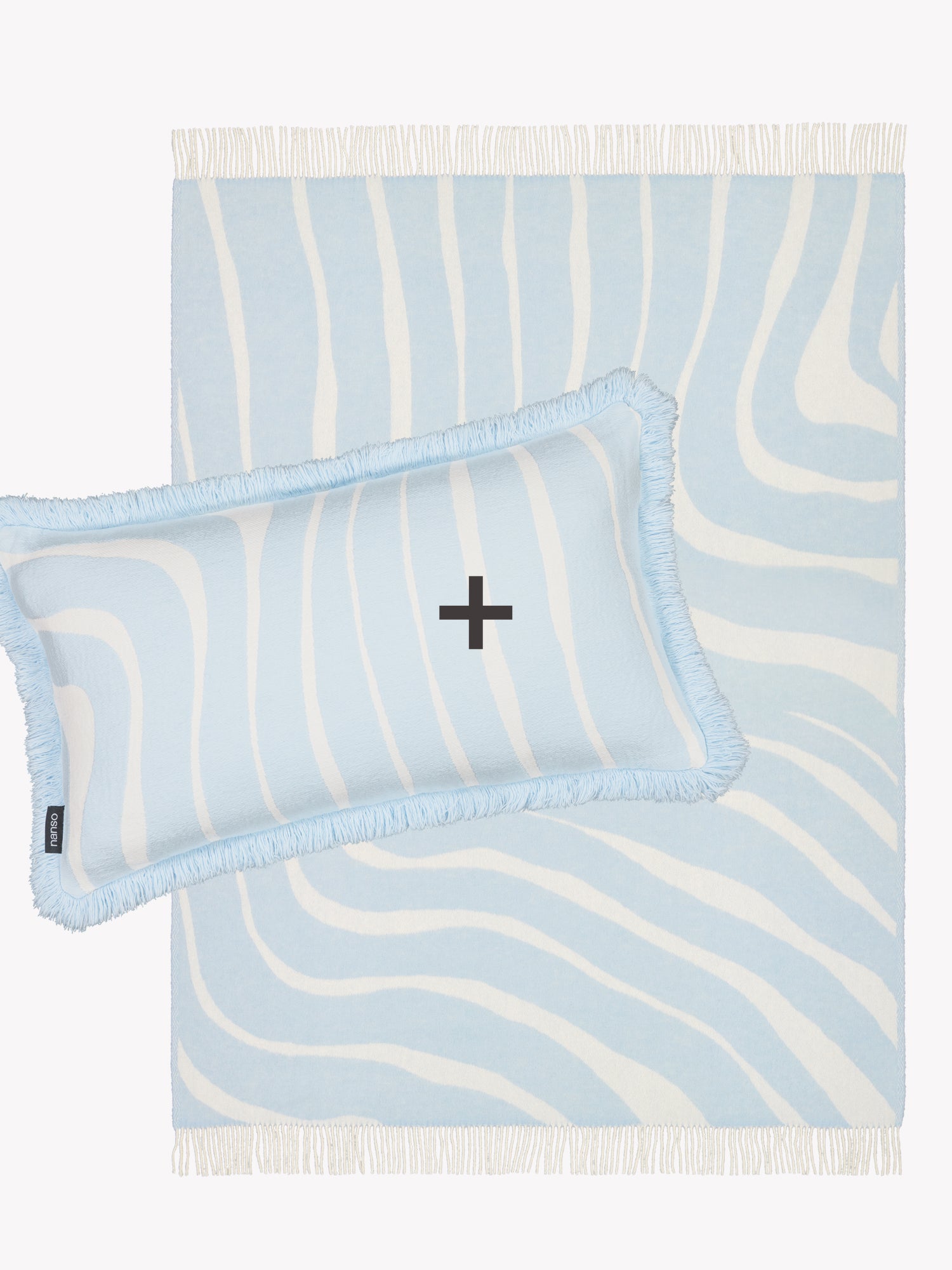 Tuotekuvassa Nanson vaaleansiniset Syli-villahuopa ja Syli-sisustustyynynpäällinen.