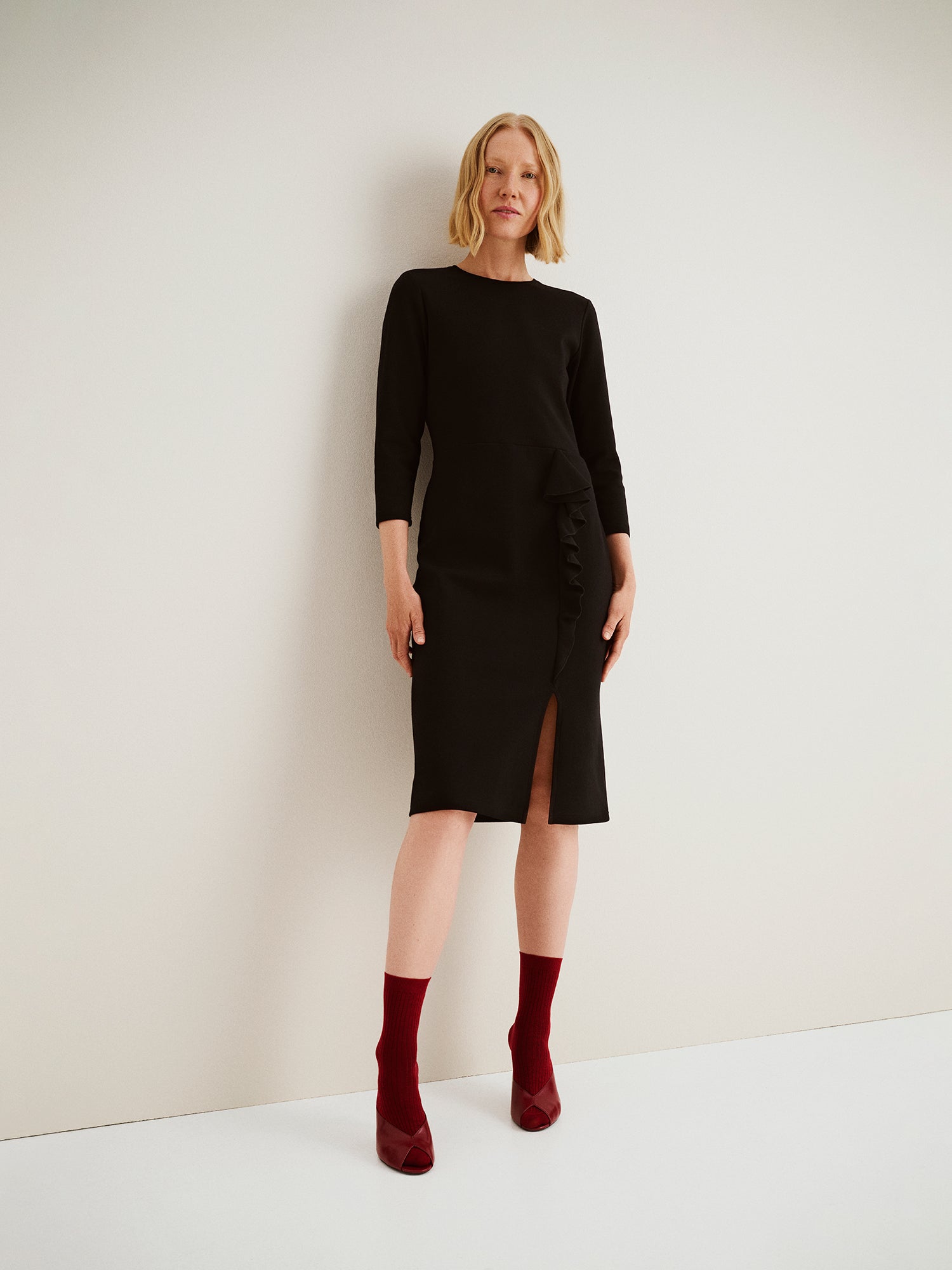 Nanson naisten musta Opera-mekko, polvipituinen istuva malli, pyöreä pääntie, halkio ja frilla, mallin yllä kokokuvassa.