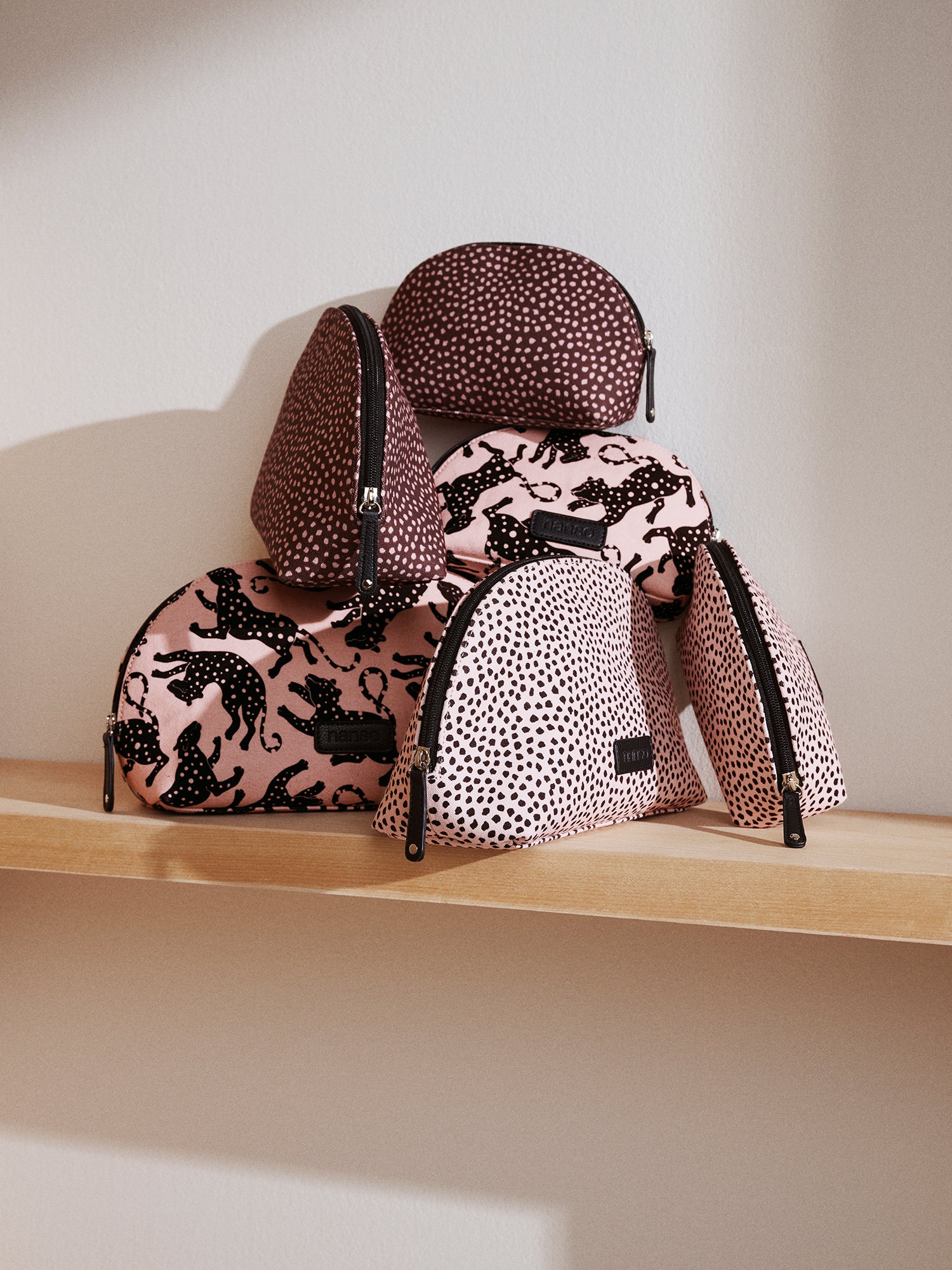 Nanson beige Leonora mini-kosmetiikkalaukku vauhdikkaalla leopardikuviolla pinossa
