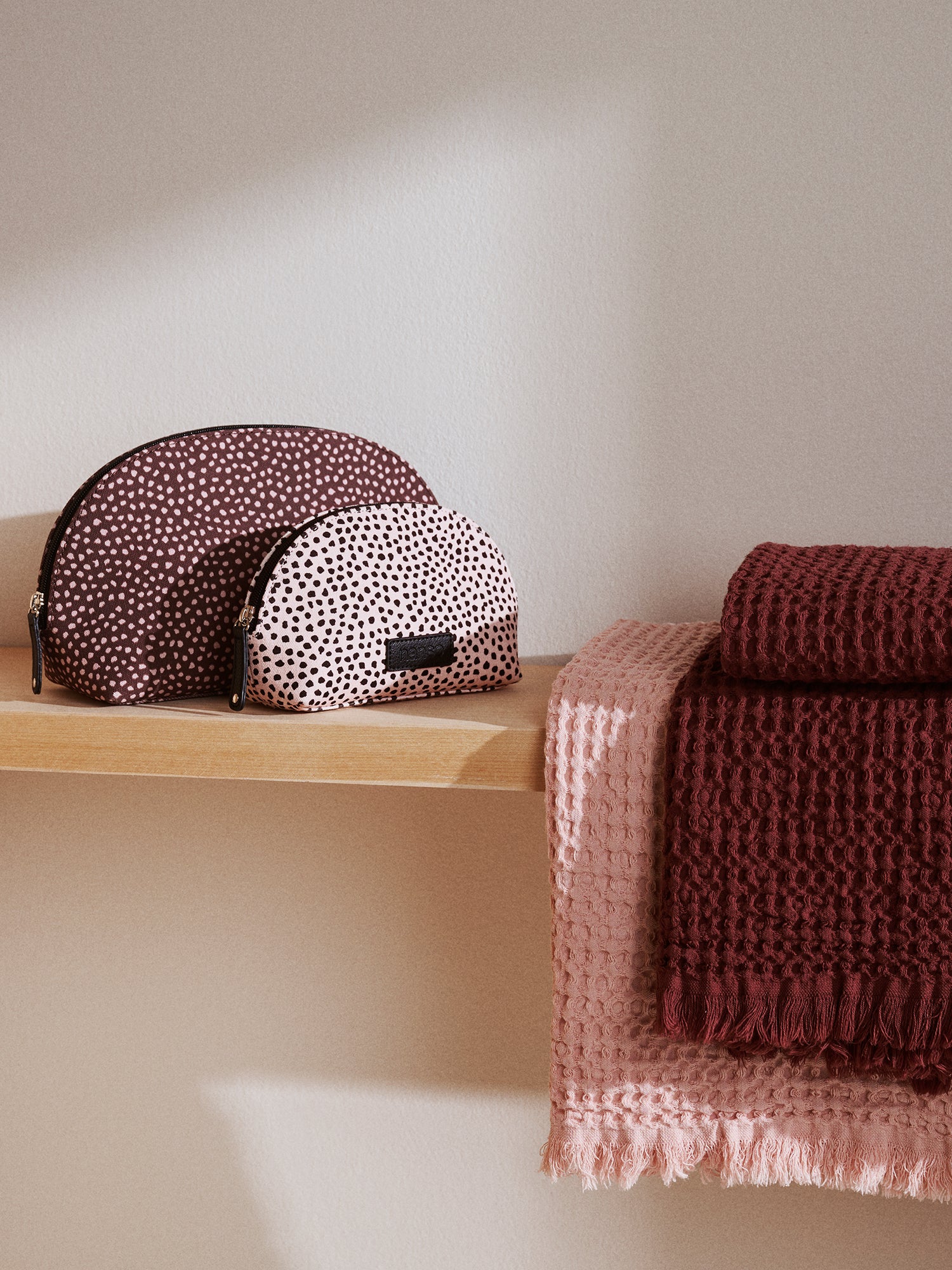 Nanson beige Muru mini-kosmetiikkalaukku ihastuttavalla sirolla pilkkukuviolla hyllyllä