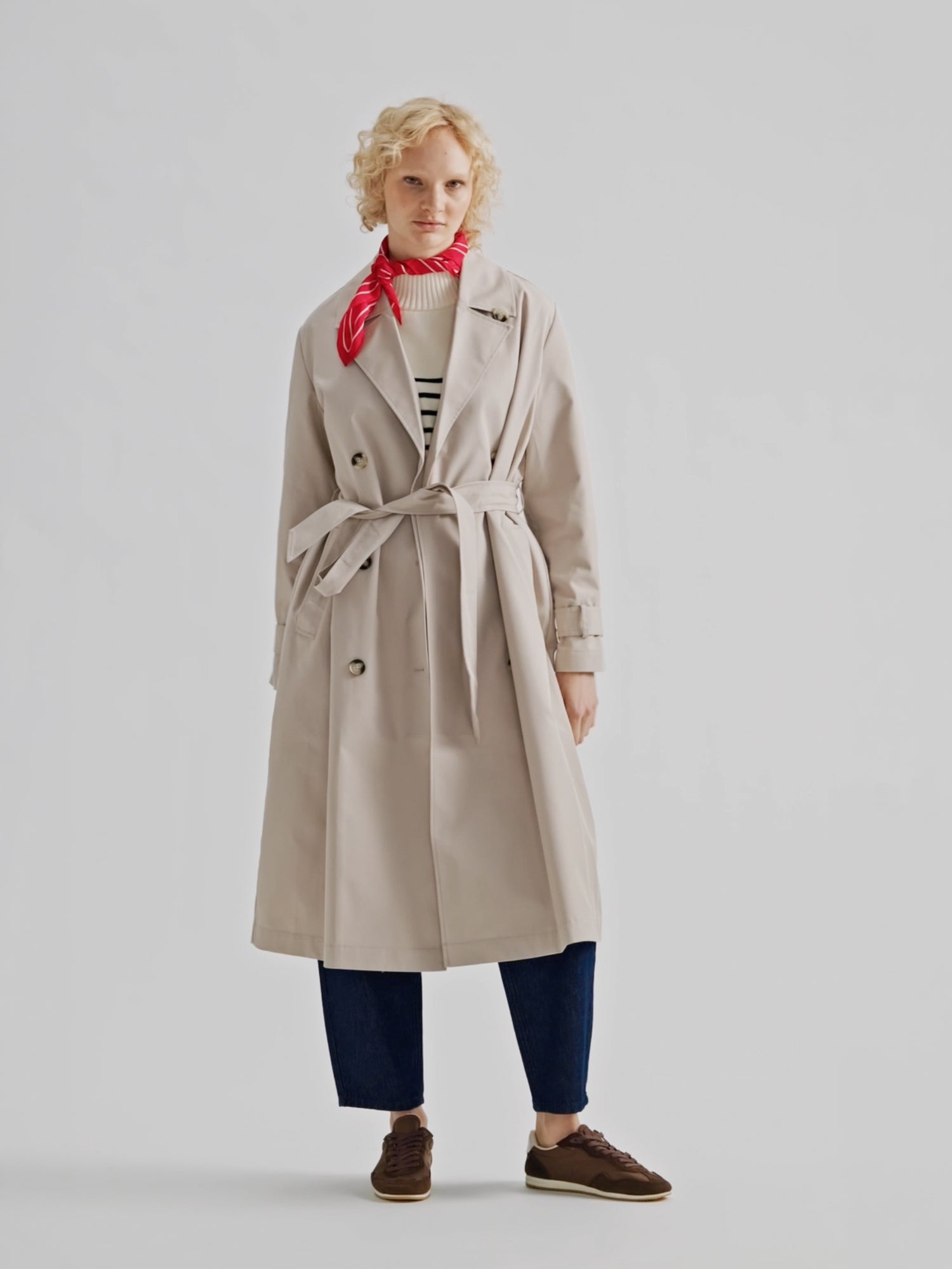 Nanson naisten klassisen tyylikäs beige Trenssi-takki vaaleahiuksisen mallin päällä.
