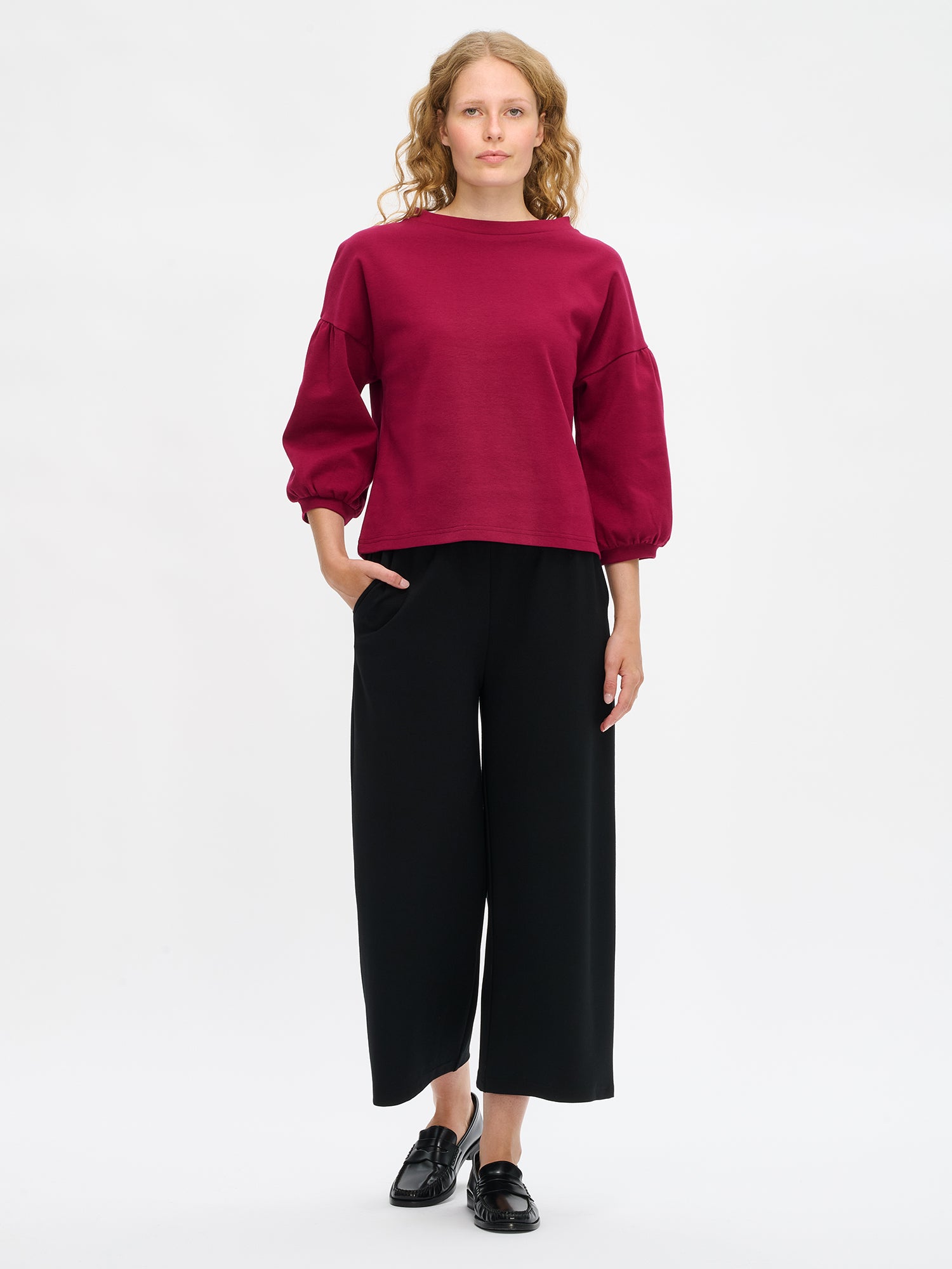 Nanson naisten viininpunainen Leija-pusero mallin yllä kokokuvassa, lantiolle ulottuva malli, 3/4 pituiset hihat poimuttuvat hihansuihin, venemuotoinen pystykaulus.