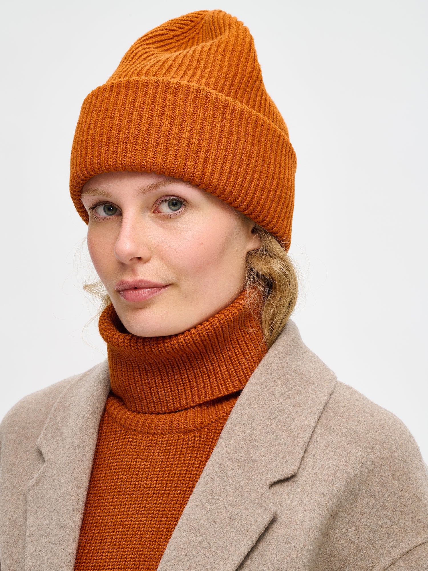 Naisten lämmin oranssin ruskea Utu-asustesetti sisältää upean Utu kaulurin sekä pipon. Niiden neulos on laadukasta, pehmeän ja miellyttävän tuntuista puuvilla-villa-sekoitetta. kuva 2