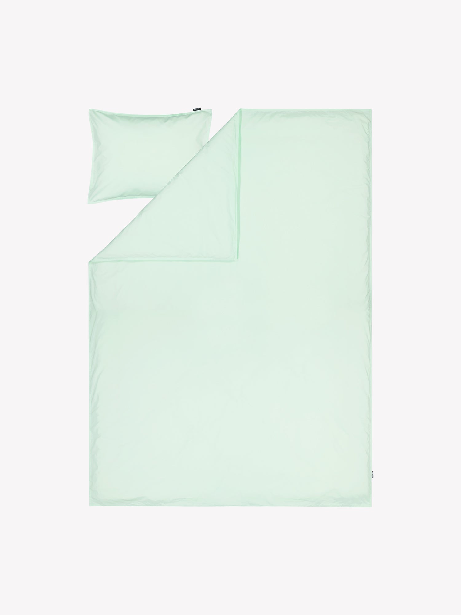 Nanson mintun sävyinen Uni-pussilakana kivipestystä tiiviistä ja korkealaatuisesta puuvillakankaasta tuotekuvassa täkin ja tyynyn päällä.