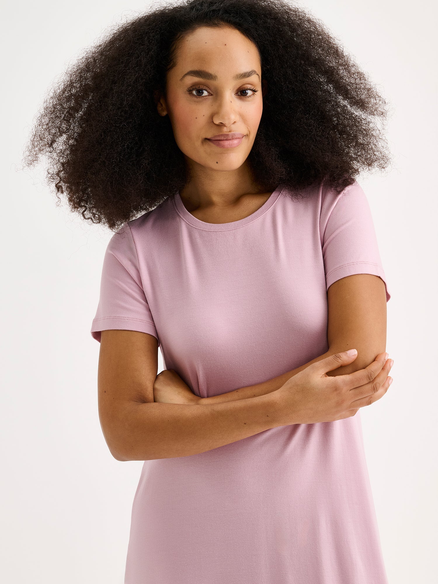 Nanson naisten ylellisen pehmeä vaaleanpunainen Pitsi-yöpaita lyhyillä hihoilla ja pyöreällä pääntiellä tummahiuksisen mallin päällä lähikuvassa.