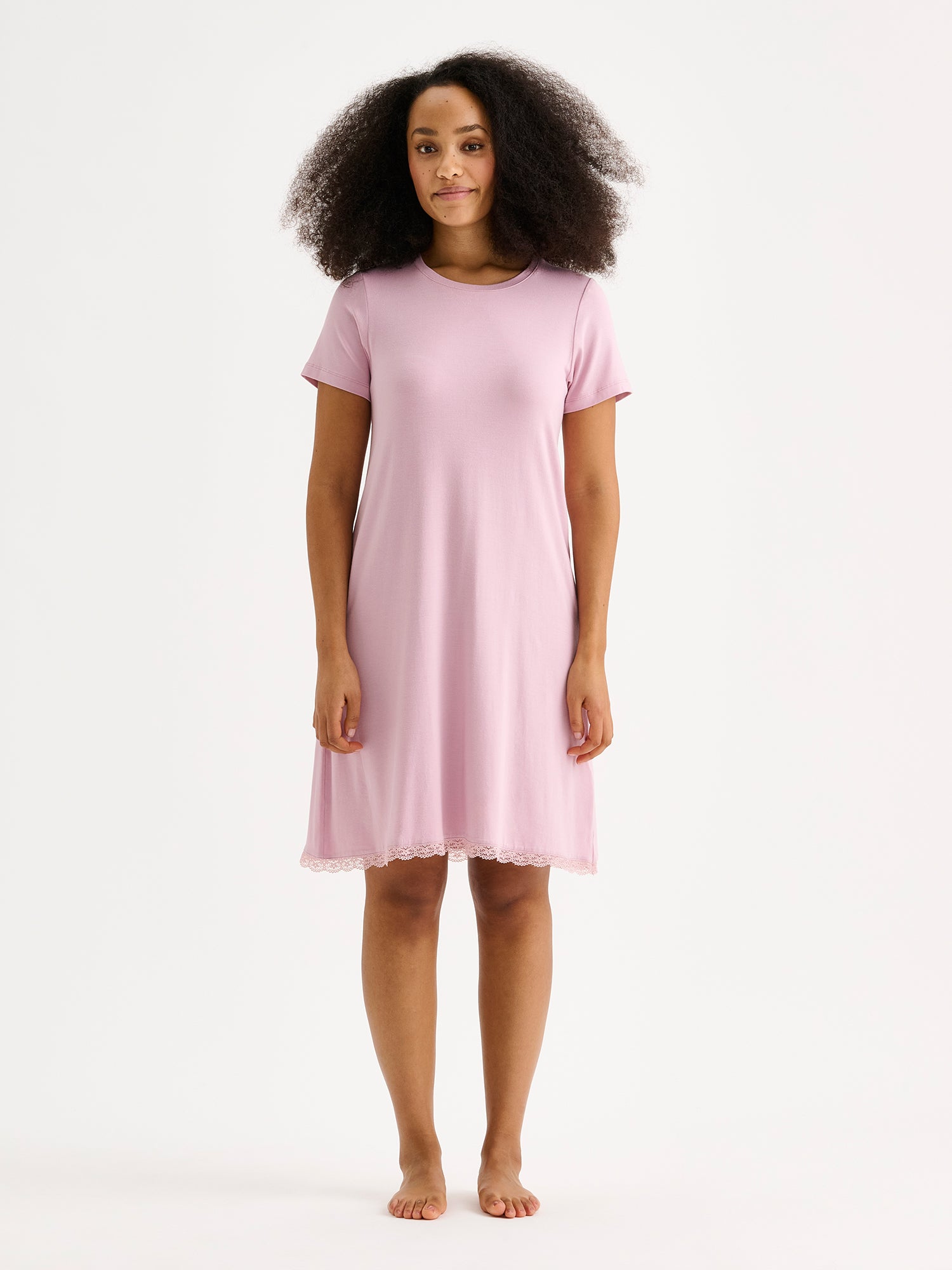 Nanson naisten ylellisen pehmeä vaaleanpunainen Pitsi-yöpaita lyhyillä hihoilla ja pyöreällä pääntiellä tummahiuksisen mallin päällä.