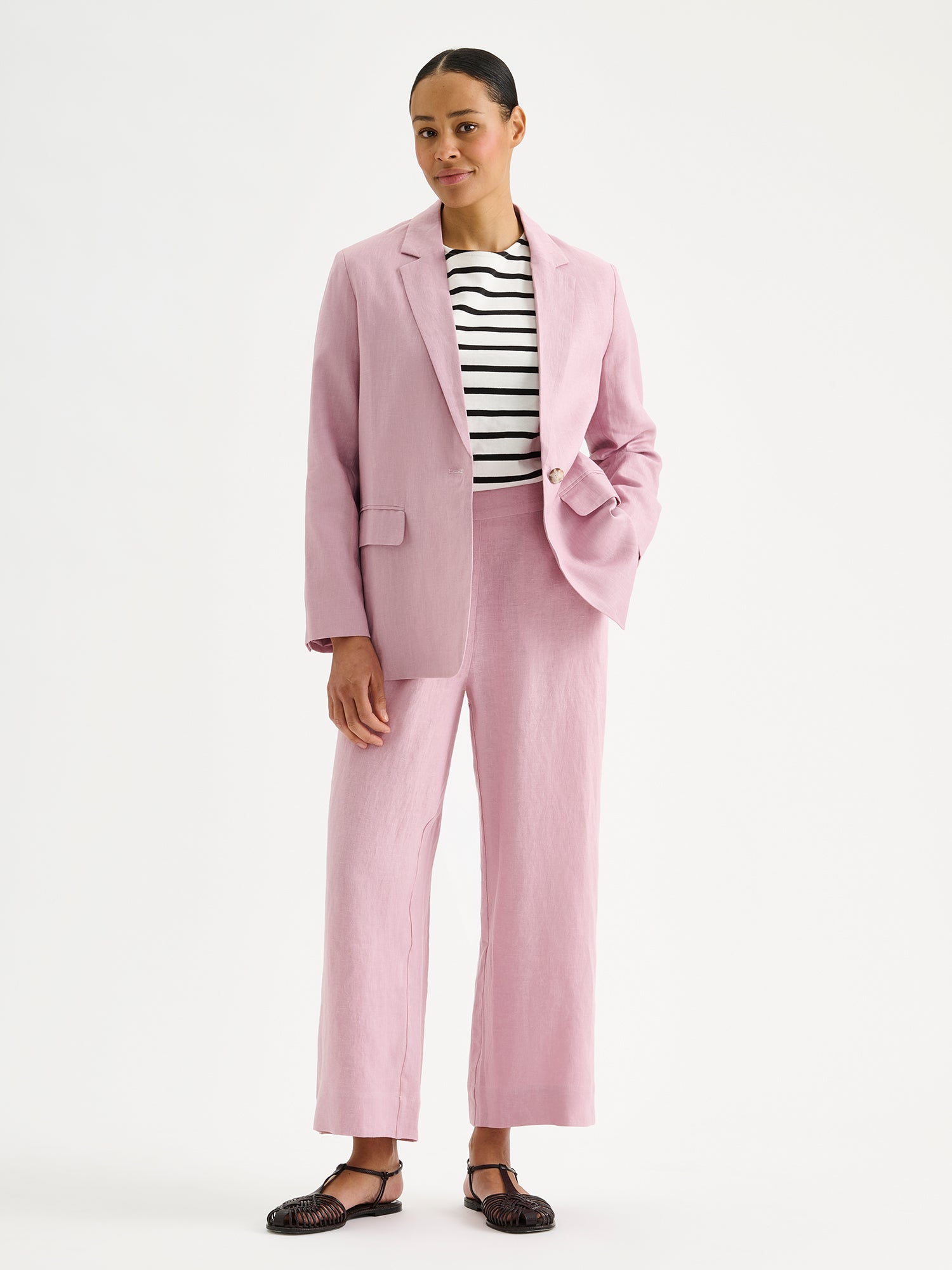 Nanson naisten tyylikäs roosa Arles-bleiseri pellavasta mallin päällä raidallisen T-paidan ja Saari Culottes -pellavahousujen kanssa.