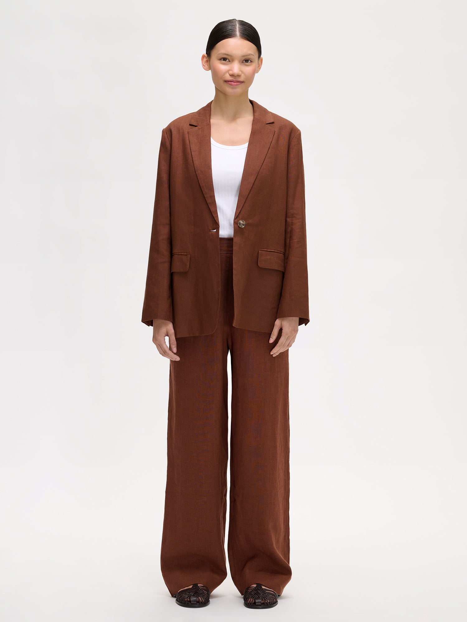 Nanson naisten tyylikäs ruskea Arles-bleiseri pellavasta mallin päällä Saari pellavahousujen kanssa.