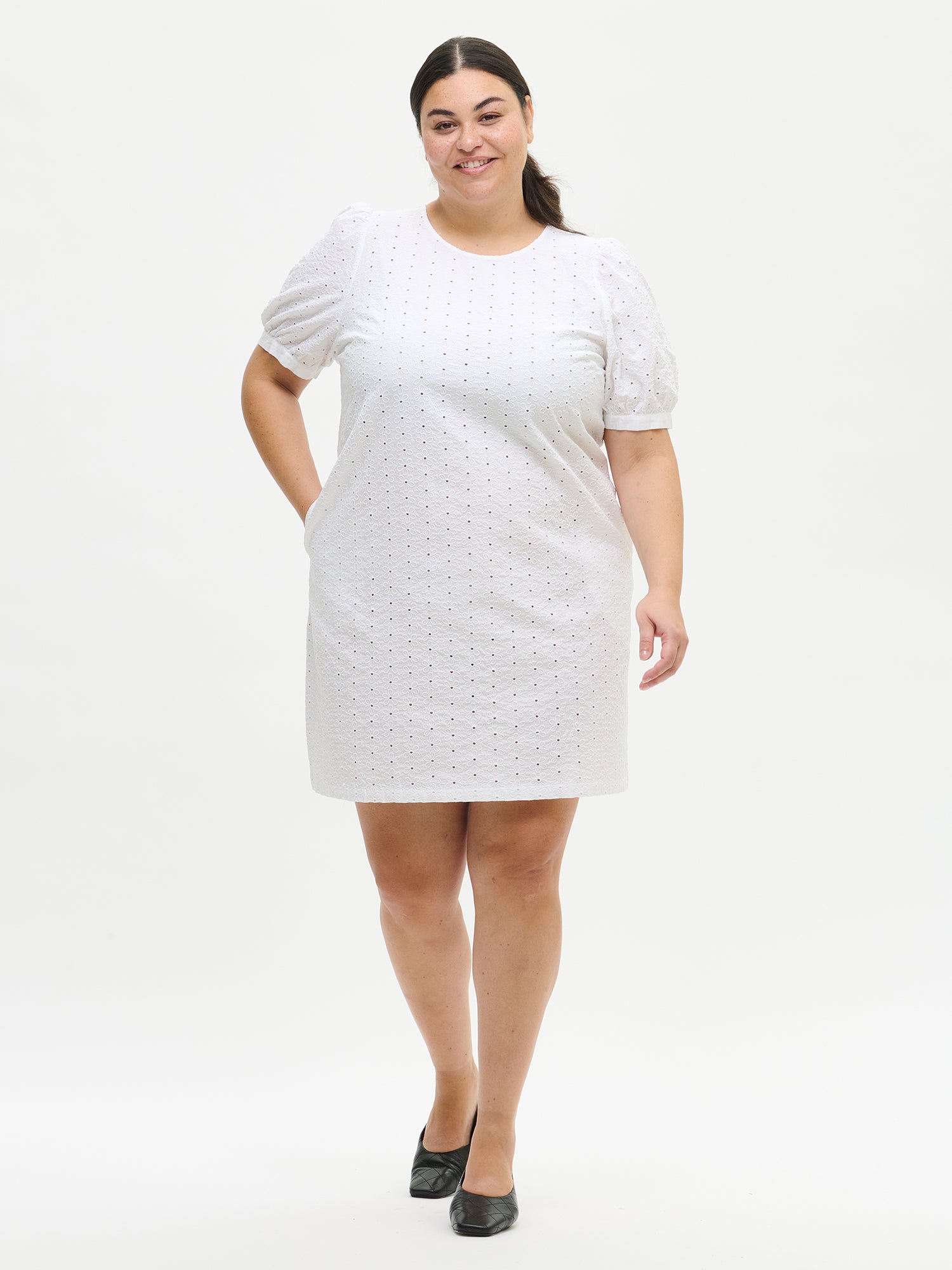 Nanson naisten valkoinen yksivärinen Petra-mekko, jonka helma ulottuu polvien yläpuolelle. Mekossa on kantilla viimeistelty pyöreä pääntie ja rintamuotolaskokset. Kuvassa Plus size -mallin yllä edestä.