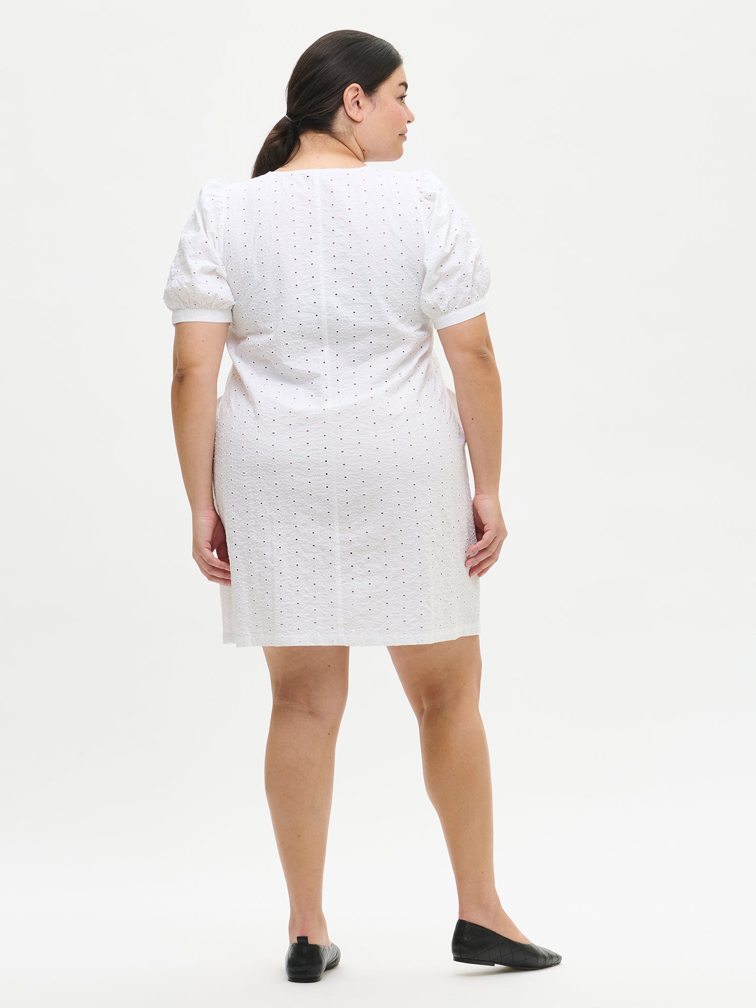 Nanson naisten valkoinen yksivärinen Petra-mekko, jonka helma ulottuu polvien yläpuolelle ja kellottuu kevyesti. Kuvassa Plus size -mallin yllä takaa.