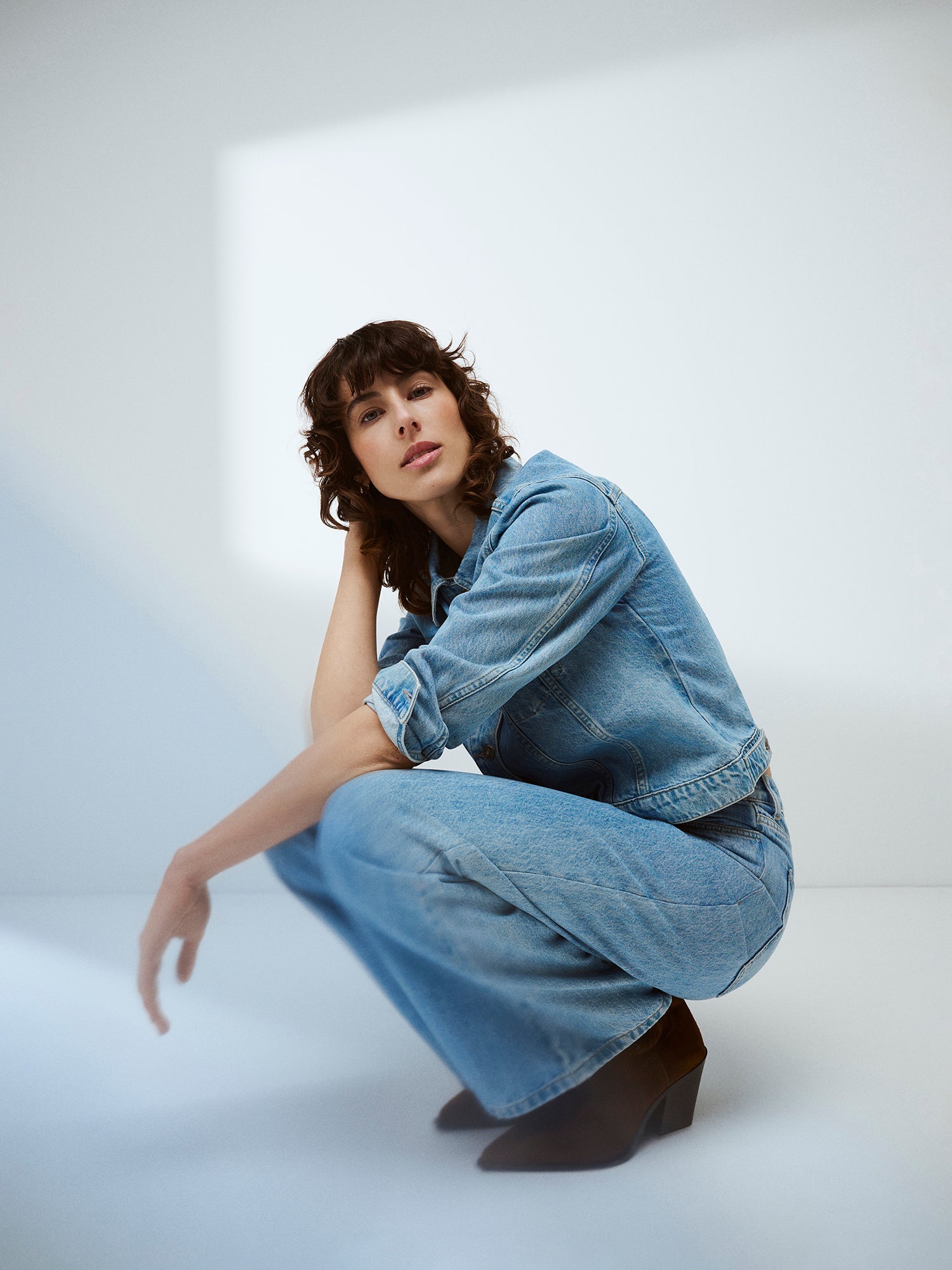 Nanson naisten klassisen vaaleansininen Denim- farkkutakki mallin päällä bootsien ja leveälahkeisten farkkujen kanssa. 