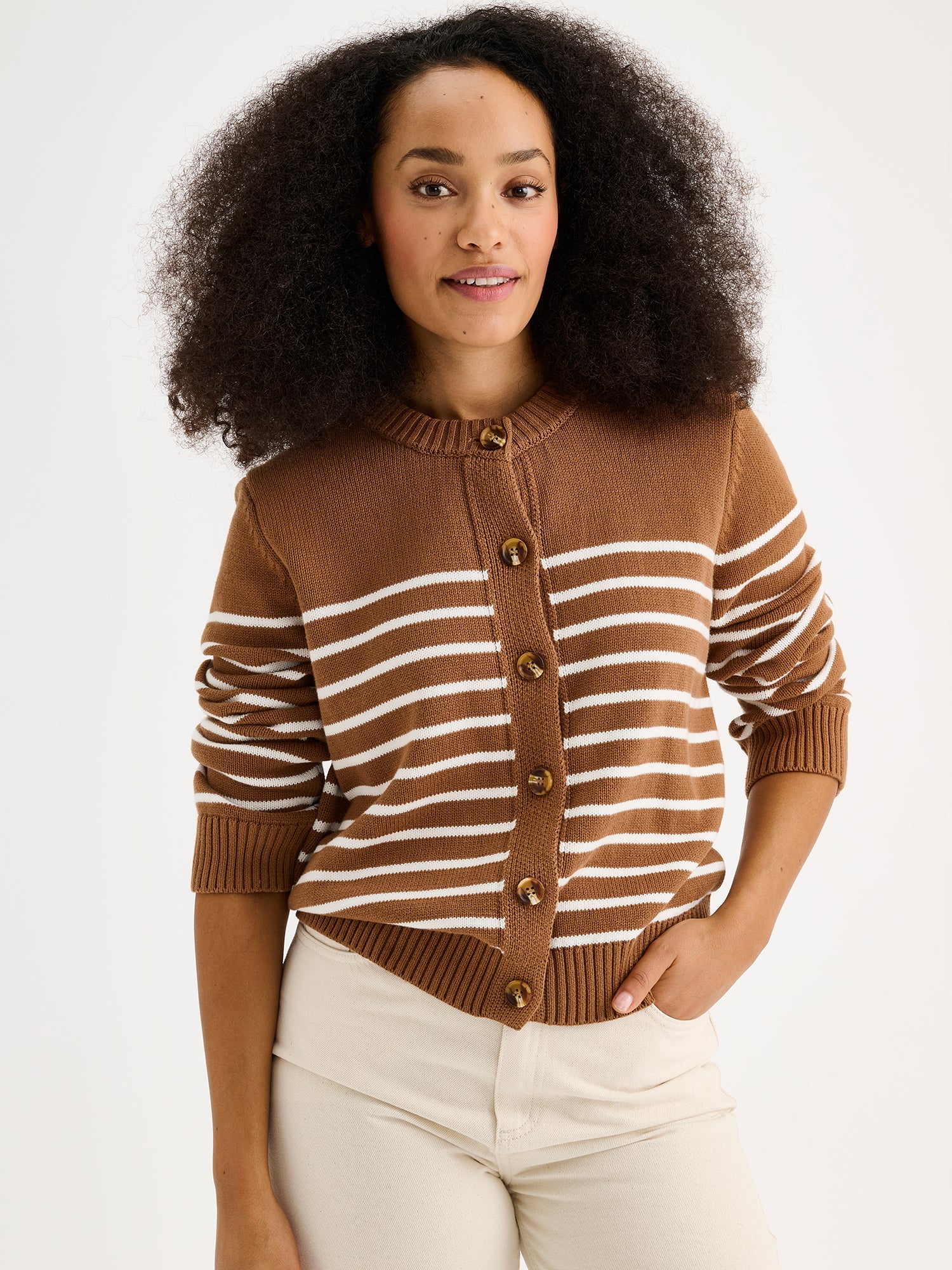 Nanson naisten pitkähihainen, ruskea-valkoinen raidallinen ja suoralinjainen Mira-neuletakki mallin päällä vaaleiden farkkujen kanssa lähikuvassa.