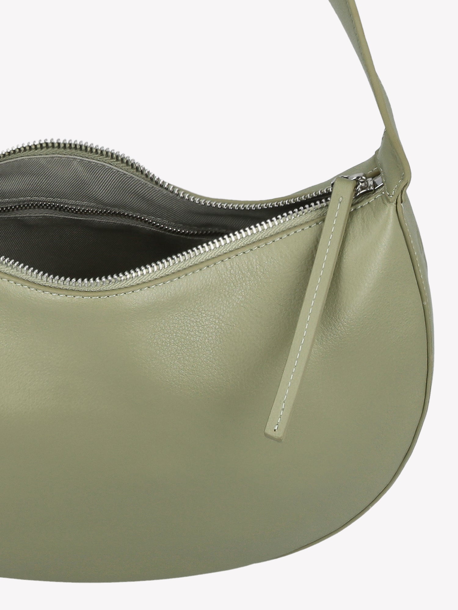 Tyylikäs ja trendikäs puolikuun mallinen vaaleanvihreä OLKA KUU - nahkalaukku. Laukussa on olalle sopiva kantohihna ja logo nahan pinnassa. Vuoritetussa laukussa on päällä metallinen vetoketju. Tuotekuva yläviistosta, niin että laukun sisälle näkee.