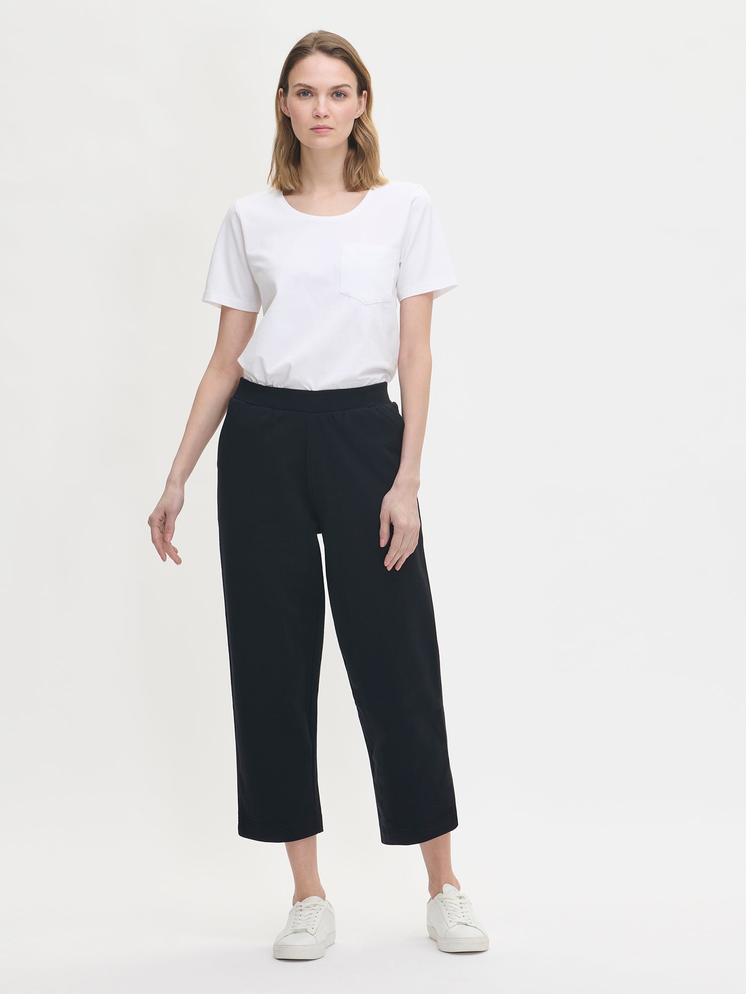 Naisten Koto culottes-housut mustassa värissä yhdistettynä tavalliseen valkoiseen t-paitaan mallin päällä edestäpäin kuvattuna. 