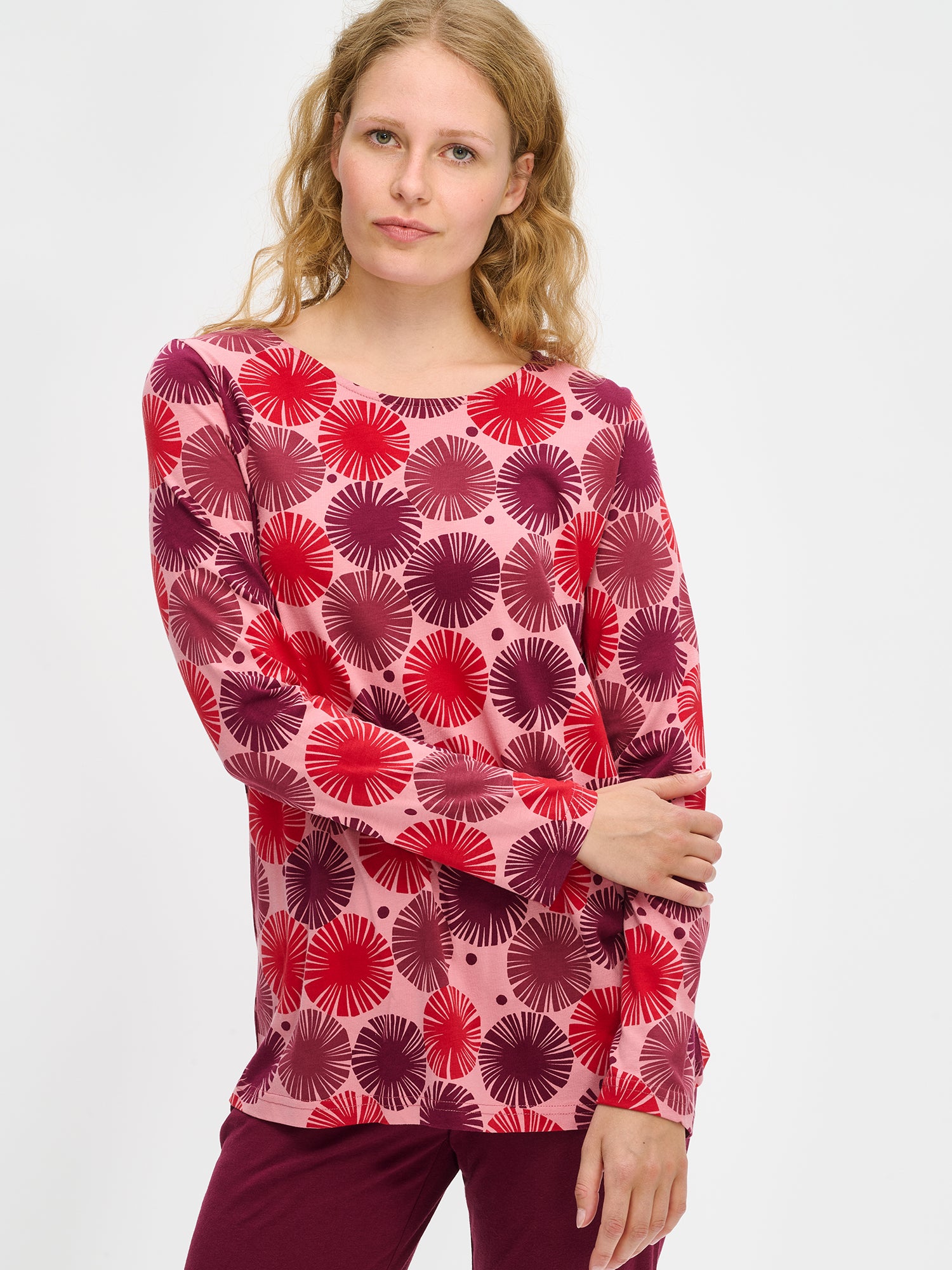 Nanson naisten Amara-pyjama, punainen graafinen kuosi ja pehmeä puuvilla-modaalimateriaali, mallin yllä puolivartalokuvassa.