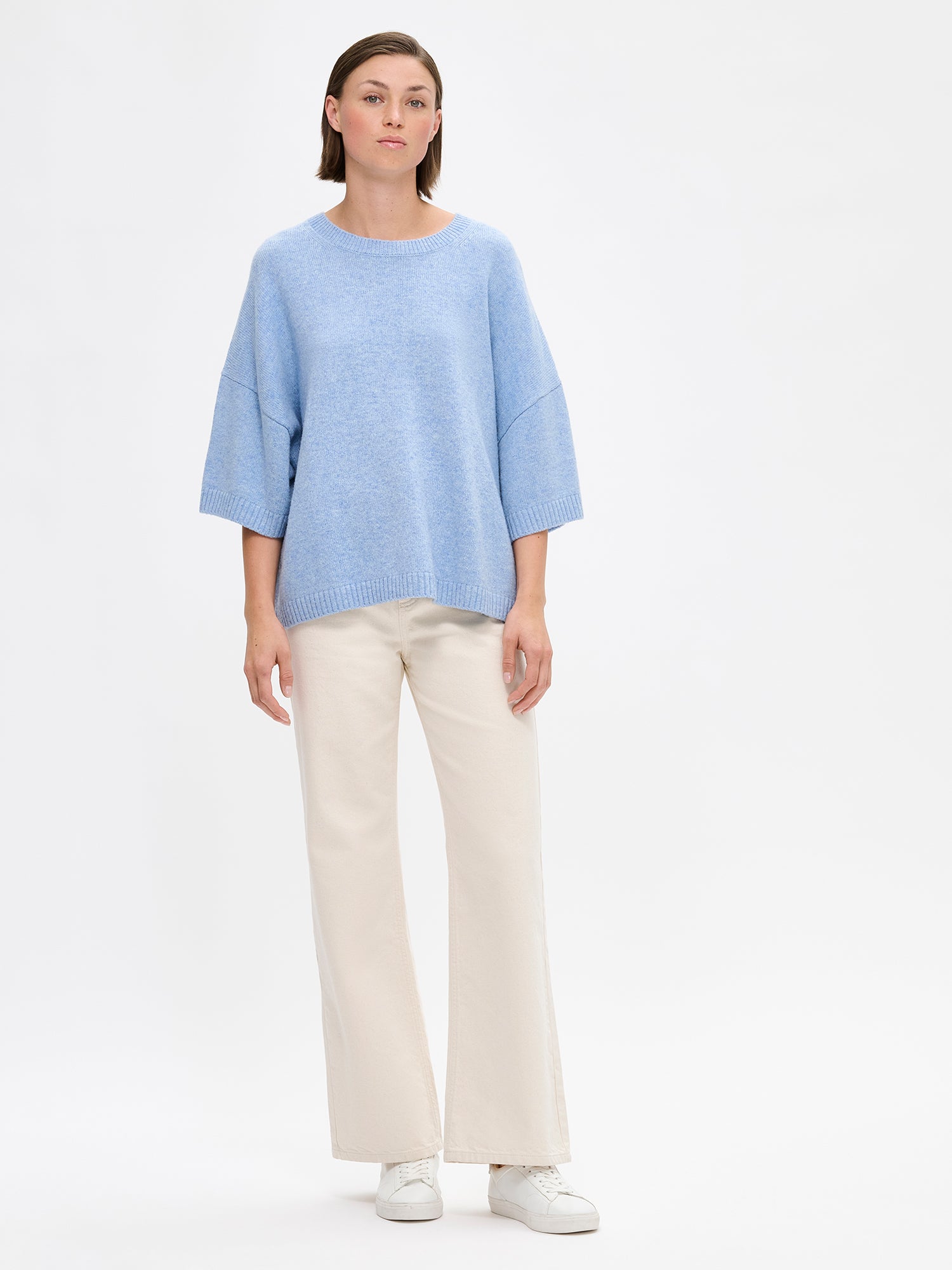 Naisten rento Oversize-tyylinen sininen Lana-neulepaita, jossa pyöreä resoripääntie, 1/2 pituiset hihat ja ribbineulos hihansuissa ja helmassa. Kuvattuna mallin päällä farkkujen kanssa.