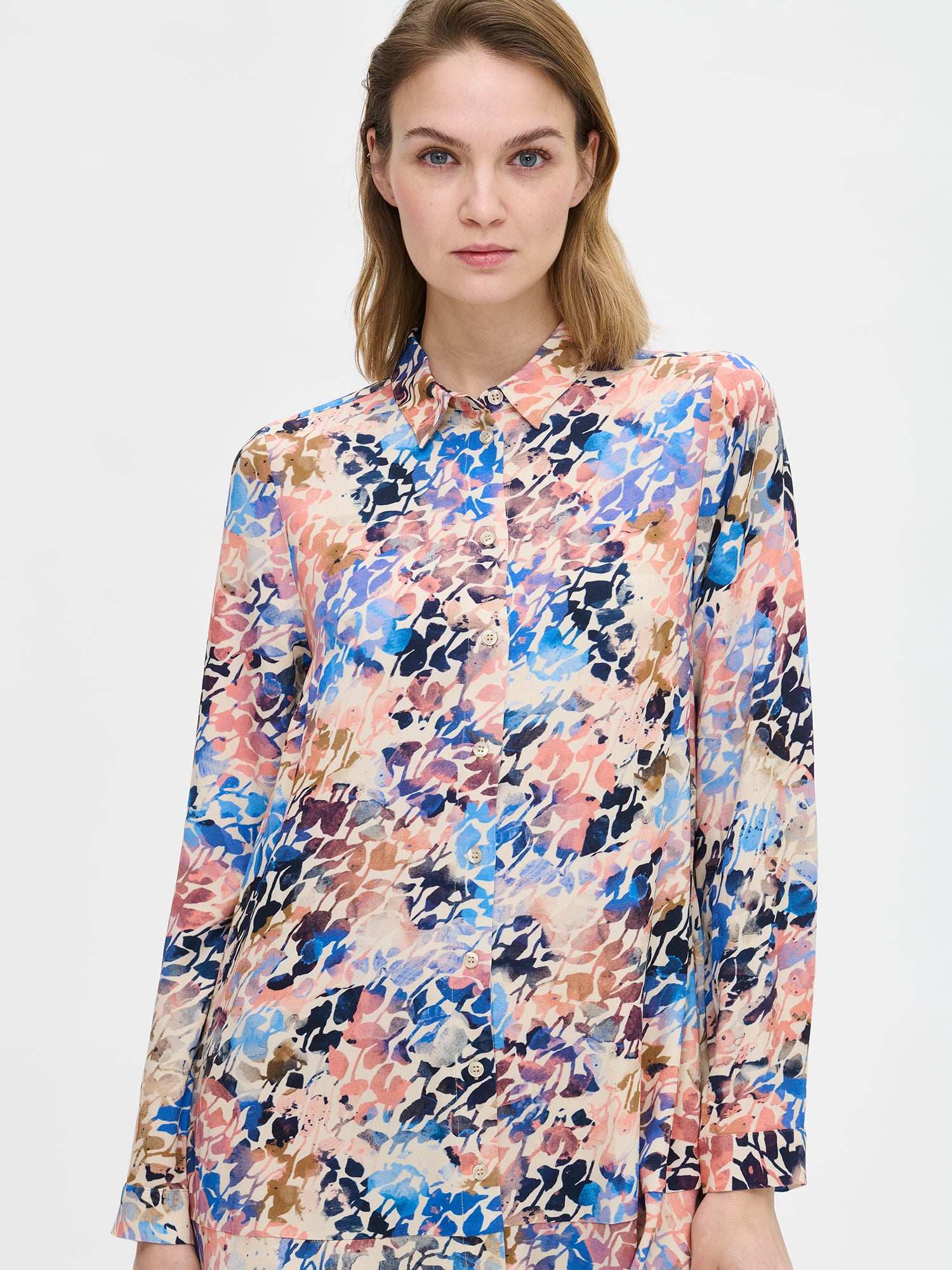 Sagitta-mekko raikkaalla kuosilla ja kellohelmalla. Kauluksellinen mekko on materiaaliltaan kauniisti laskeutuvaa viskoosia. Pitkähihaisessa mekossa on edessä napitus. Kuvassa mallin päällä läheltä kuvattuna.