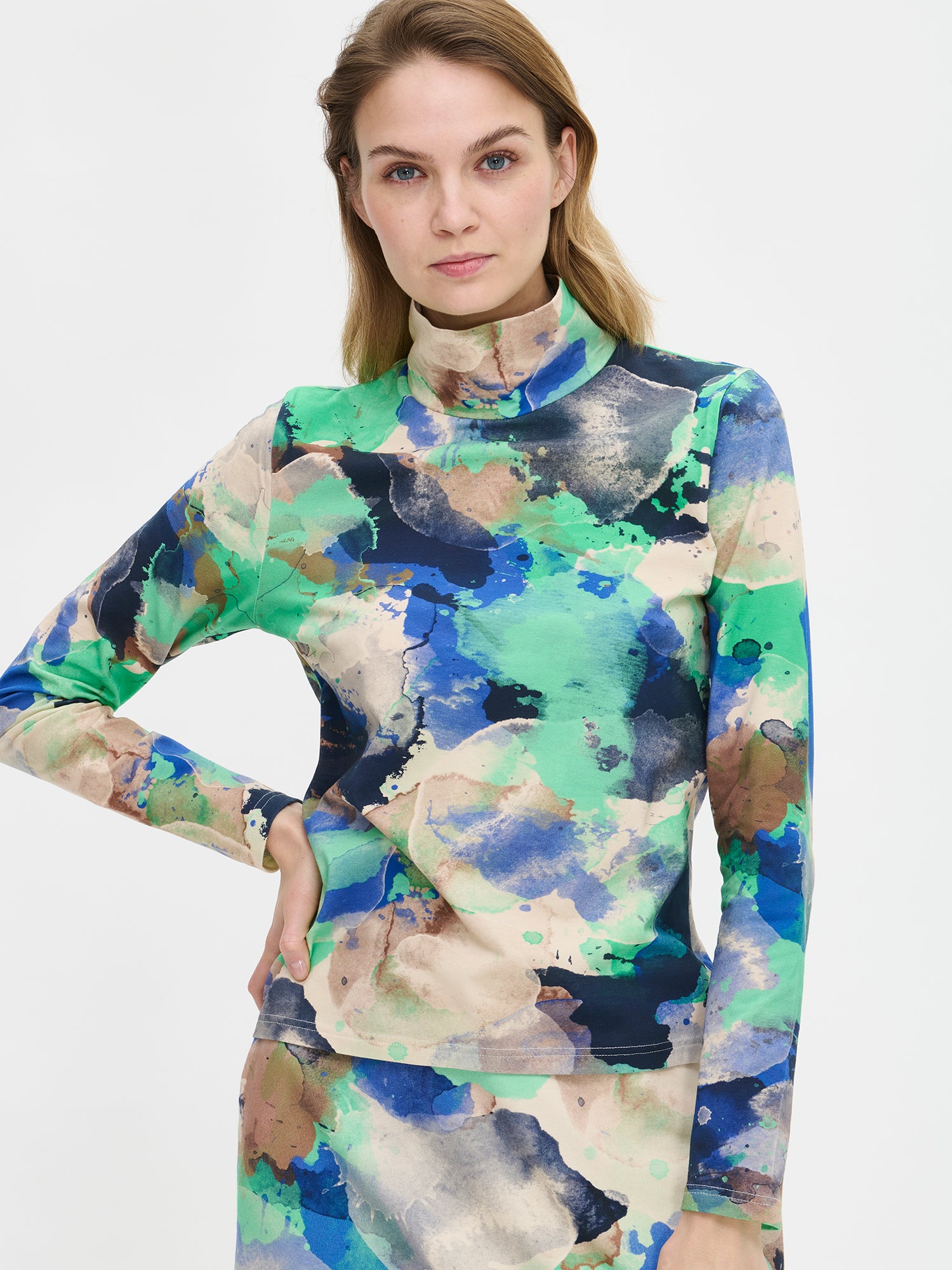 Naisten kuviollinen Sirius-pusero näyttävällä abstraktilla kuosilla ja poolokauluksella. Materiaalina laadukas joustava puuvilla-elastaanineulos. Mallin päällä, lähikuva.