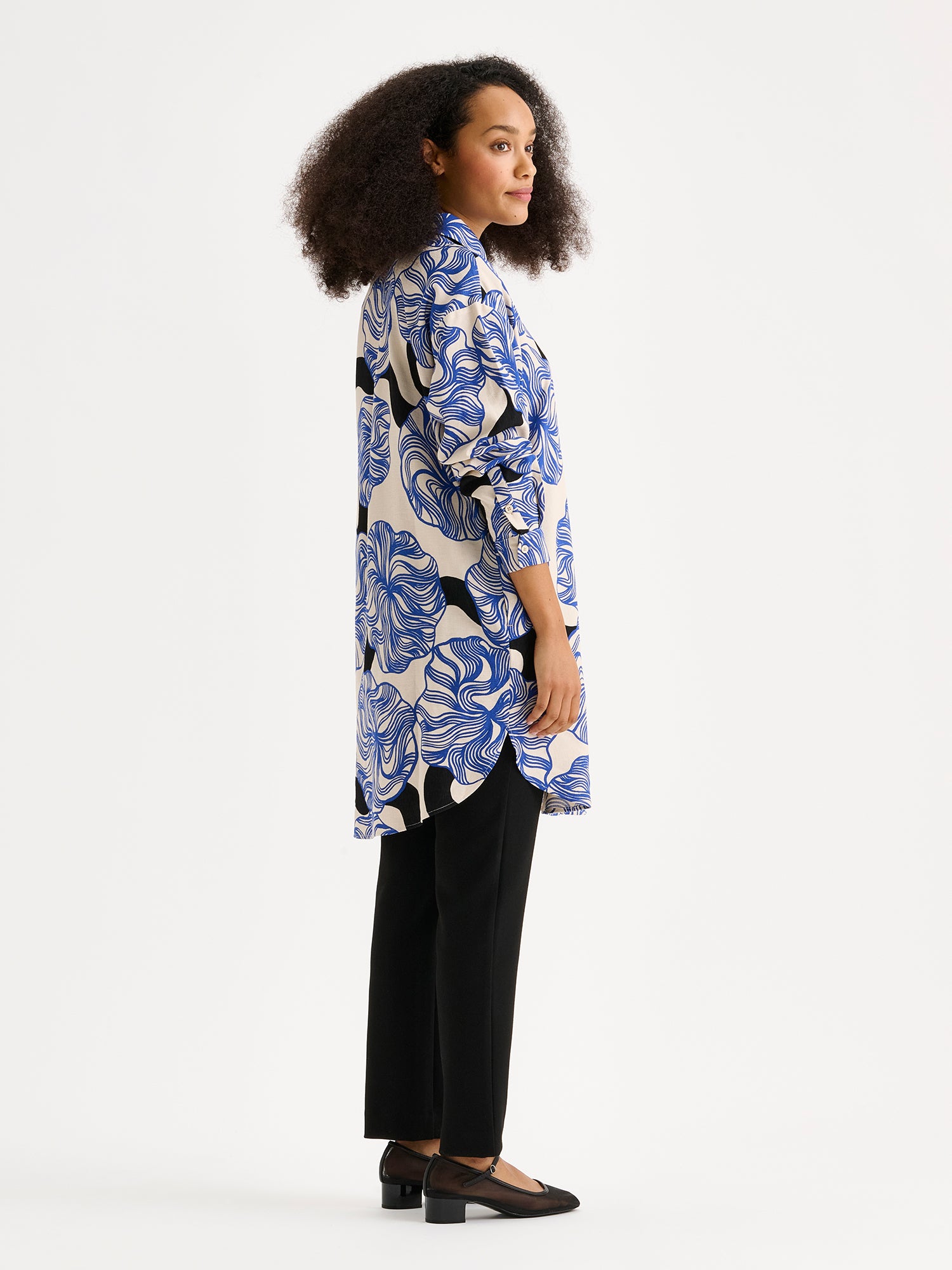 Nanson naisten Kosmo-kauluspaidassa yhdistyy klassinen malli ja näyttävä sinisävyinen kuosi. Paidassa on klassinen kaulusmalli, täyspitkät hihat, sivutaskut ja napitus edessä. Kuvassa mallin päällä sivusta kuvattuna.