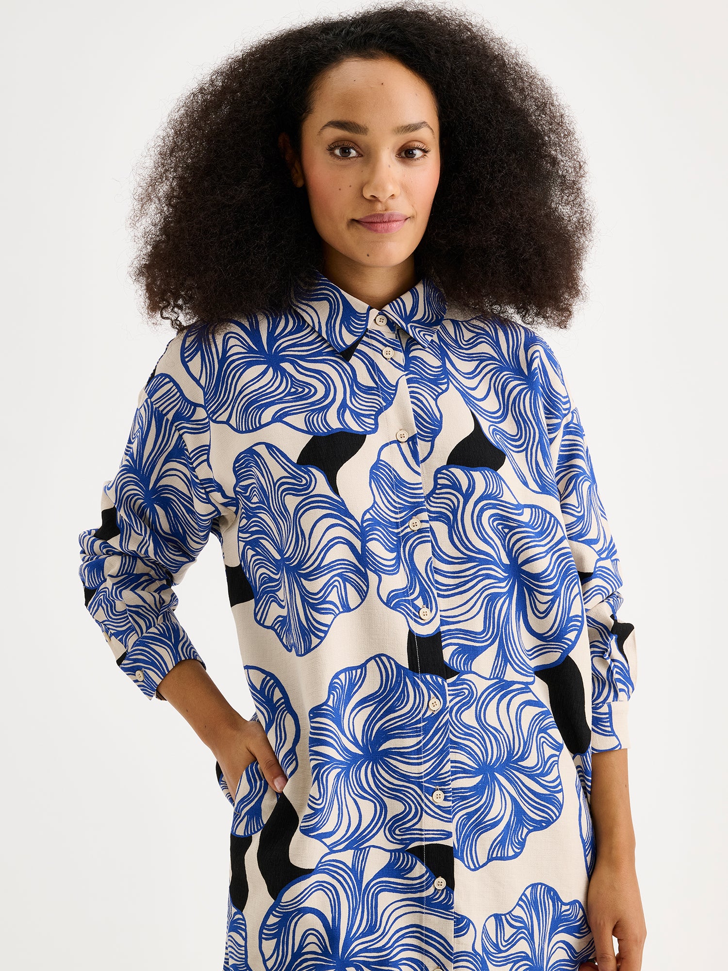 Nanson naisten Kosmo-kauluspaidassa yhdistyy klassinen malli ja näyttävä sinisävyinen kuosi. Paidassa on klassinen kaulusmalli, täyspitkät hihat, sivutaskut ja napitus edessä. Kuvassa mallin päällä läheltä kuvattuna.