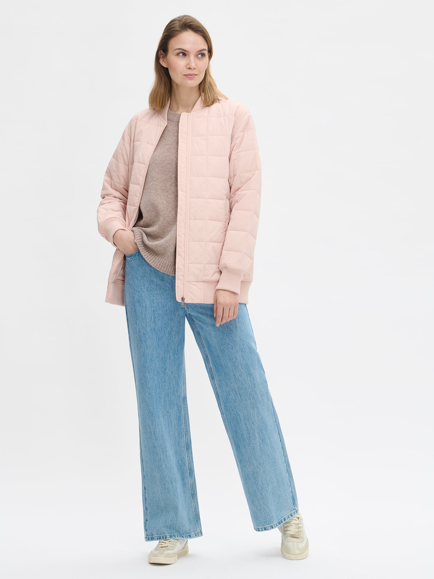 Nanson naisten rento Merje bomber tikkitakki kevyellä vanulla. Takin pääntiellä, hihansuissa ja helmassa on neulosresori. Edessä on vetoketju ja taskut. Takin olkalinja on pudotettu. Mallin päällä auki farkkujen kanssa kuvattuna.