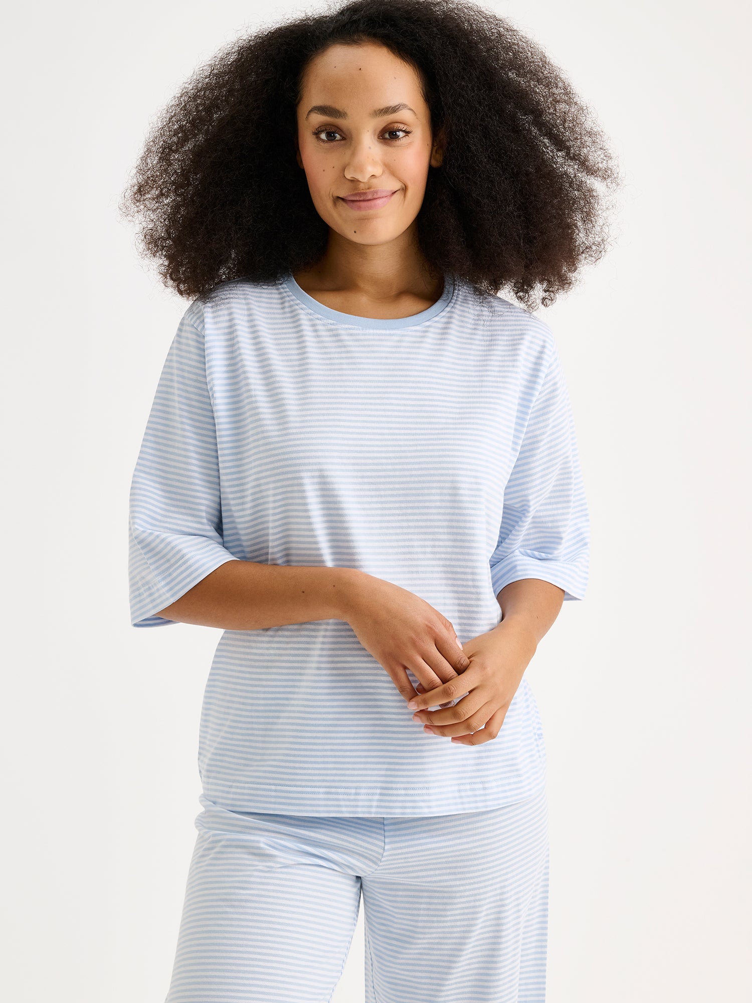 Naisten raikkaan sininen raidallinen Tyyni-pyjama mallin päällä lähikuvassa