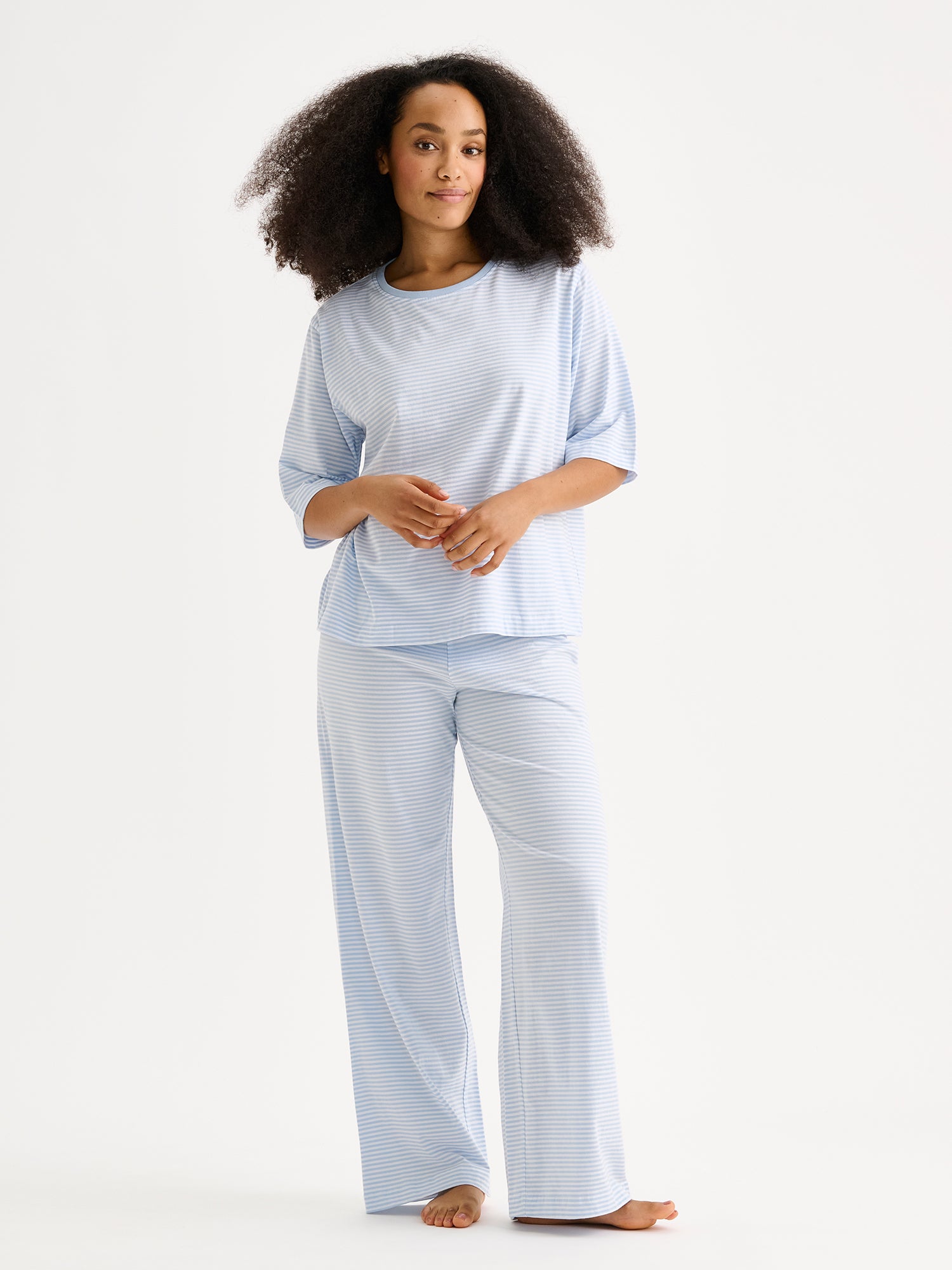 Naisten raikkaan sininen raidallinen Tyyni-pyjama mallin päällä