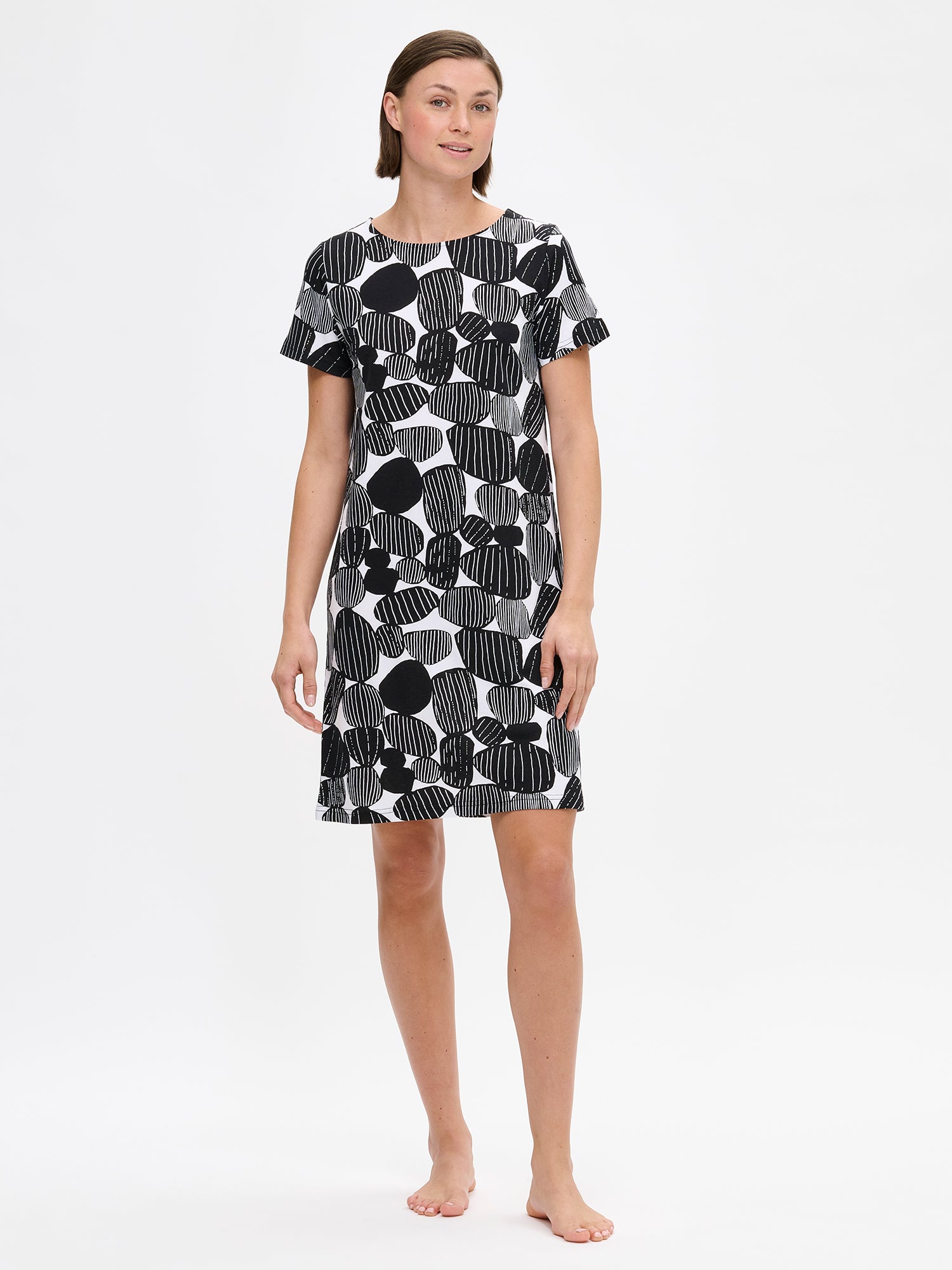 Nanson naisten musta kuosillinen Kummeli-yöpaita lyhyillä hihoilla ja ovaalilla pääntiellä, pehmeää puuvilla-modaalia. Kuvattuna mallin päällä edestä.