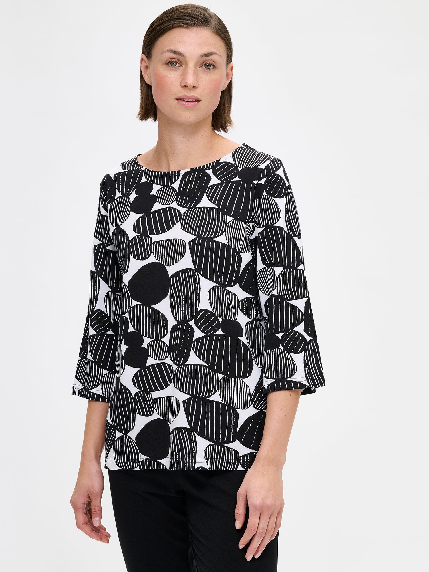 Nanson naisten musta kuosillinen Kummeli-pyjama 3/4 pituisilla hihoilla ja ovaalilla pääntiellä, pehmeää puuvilla-modaalia. Mallin päällä edestä kuvattuna, läheltä.