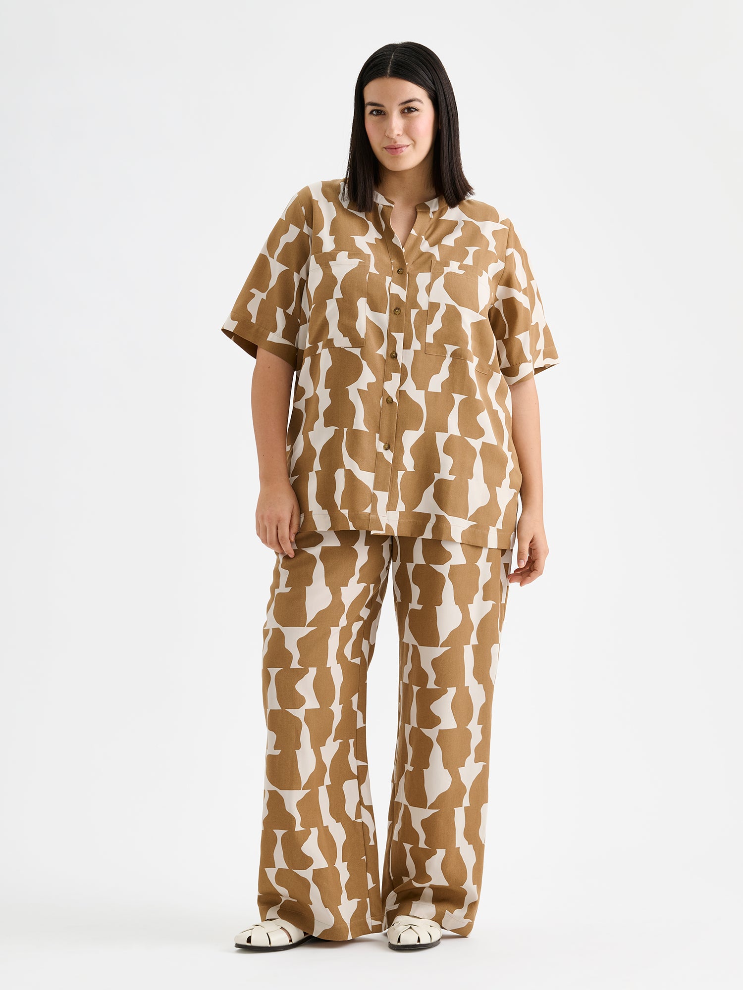 Kuosilliset ruskeansävyiset Soraja -pusero ja housut, mallin päällä.