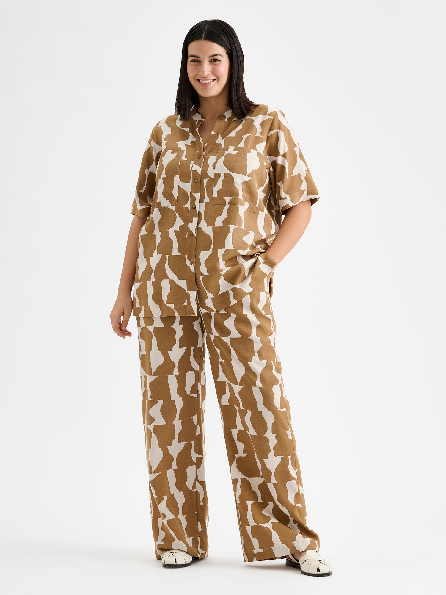 Kuosilliset ruskeansävyiset Soraja -pusero ja housut, mallin päällä.