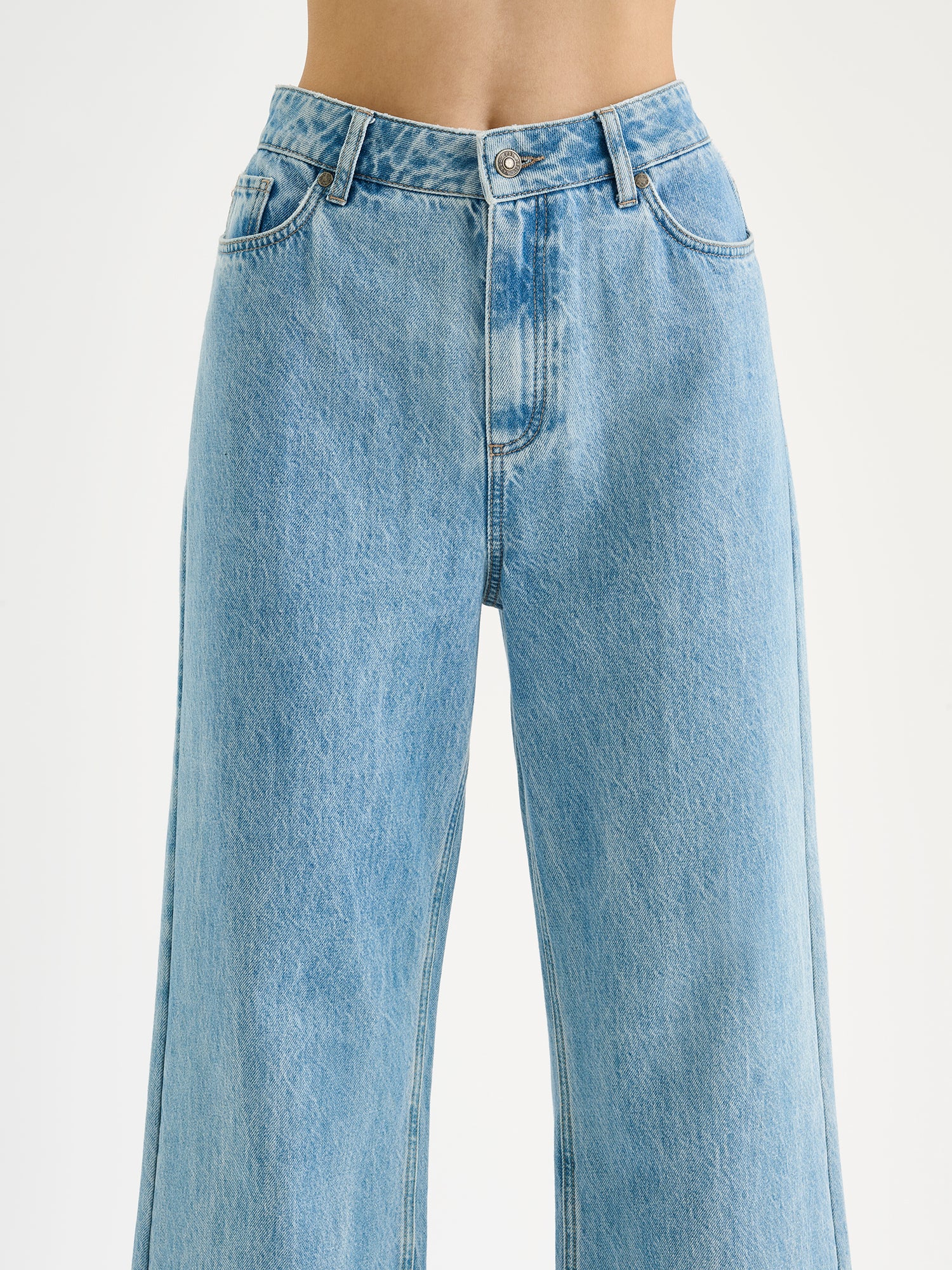 Nanson naisten vaaleansiniset leveälahkeiset Levee-farkut korkealla vyötäröllä mallin päällä lähikuvassa.