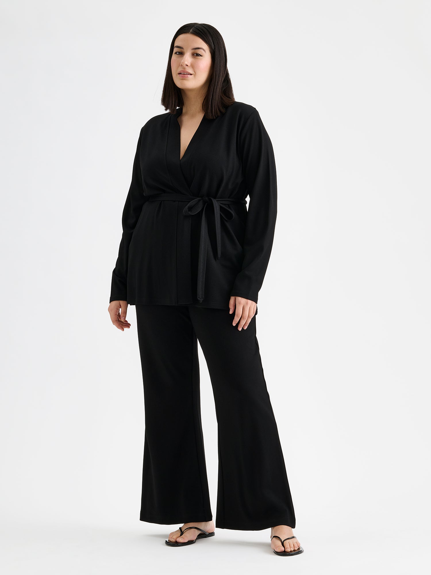 Naisten rennon tyylikkäät Roma-housut trendikkäillä levenevillä lahkeilla mallin päällä Roma jakun kanssa.