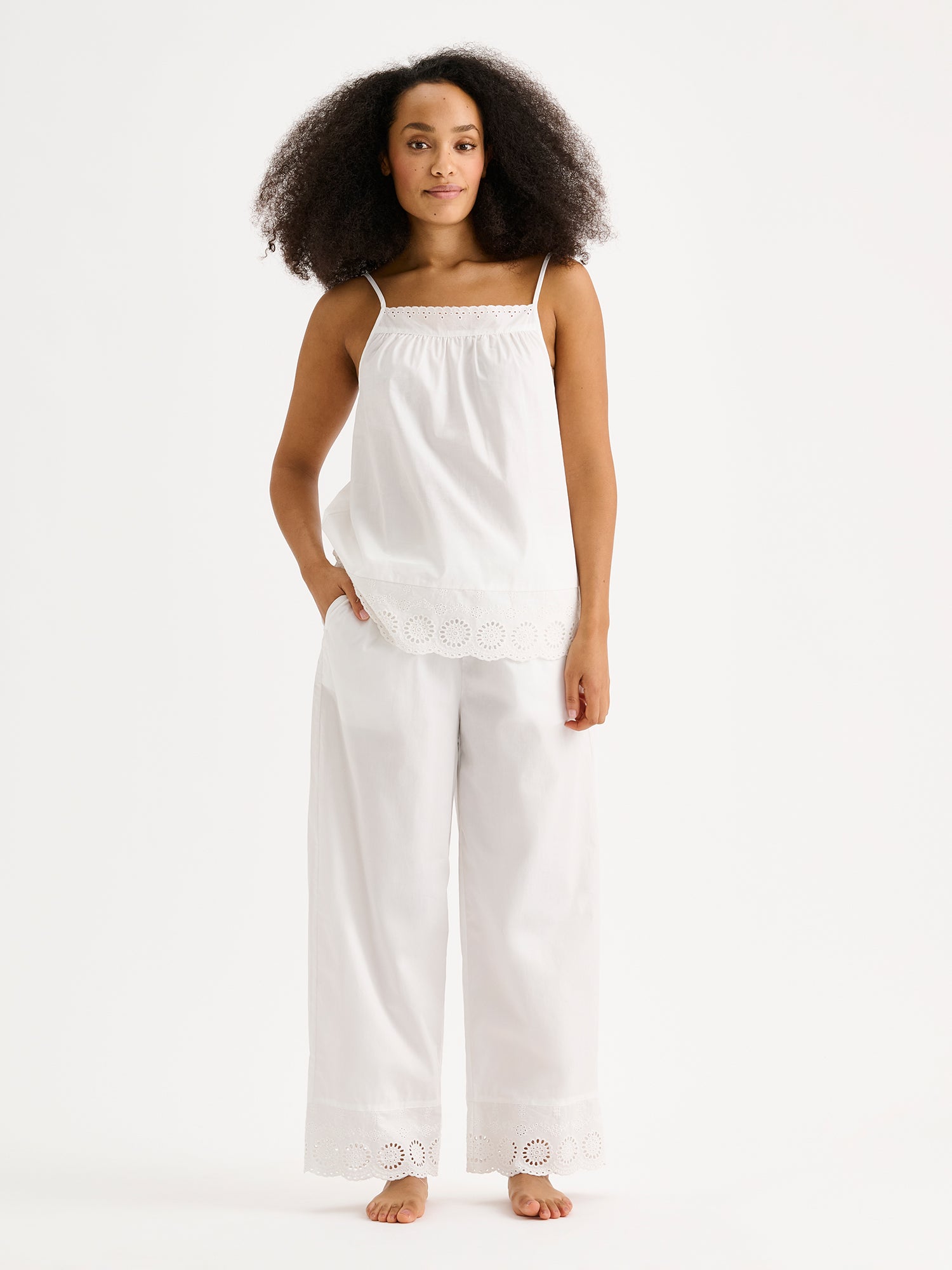 Nanson naisten valkoiset Juhannus-pyjamahousut, joissa on ihastuttavaa pitsiä lahkeissa, mallin päällä saman sarjan topin kanssa.