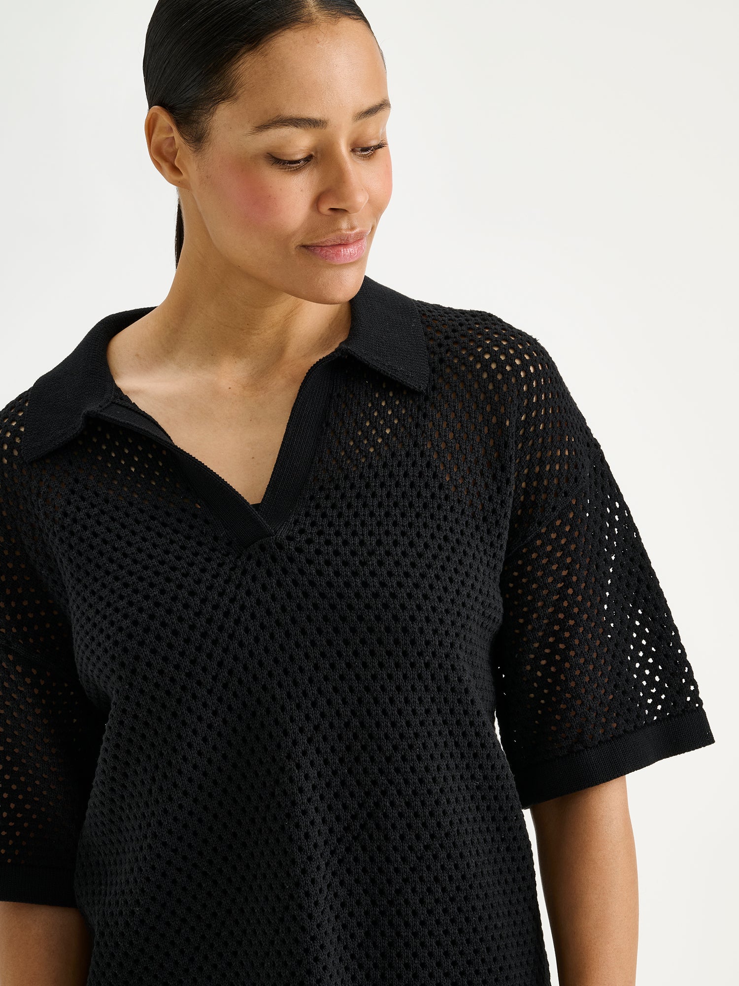 Nanson naisten musta Aure -reikäneulepusero mallin päällä lähikuvassa.