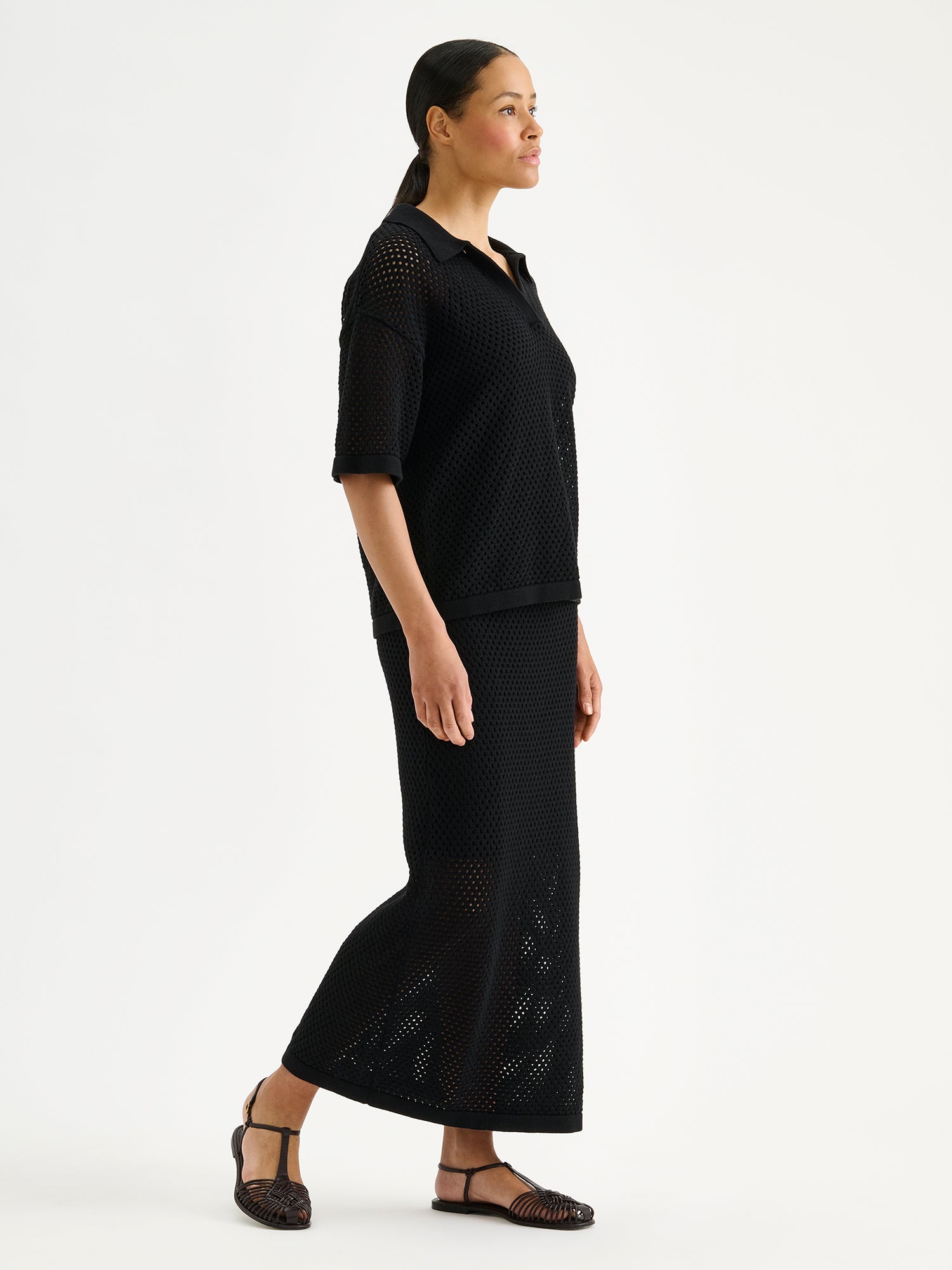 Nanson naisten trendikäs musta Aure -reikäneulehame ja -neulepusero mallin päällä 