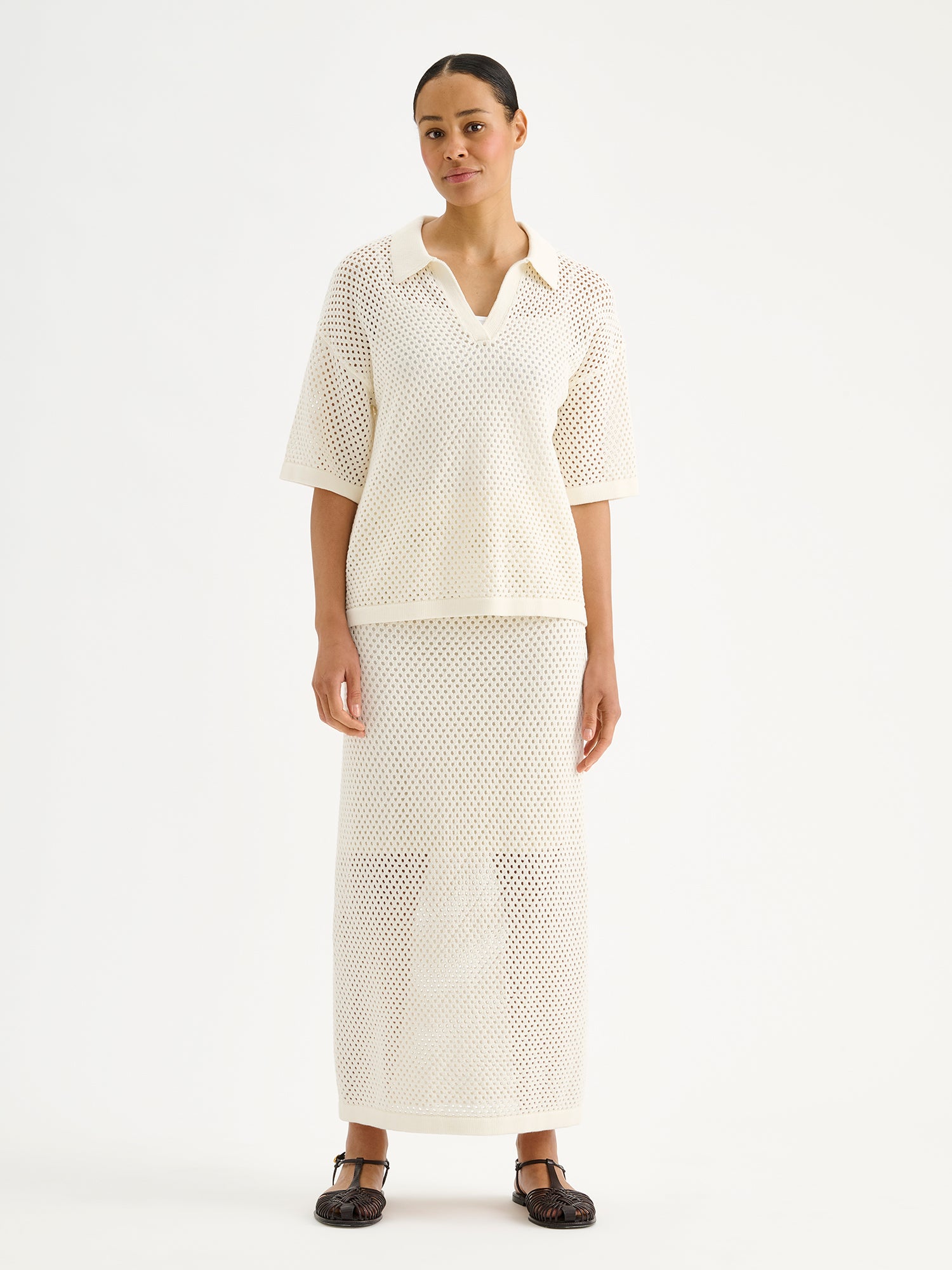 Nanson naisten trendikäs luonnonvalkoinen Aure -reikäneulehame mallin päällä Aure -reikäneulepaidan kanssa.