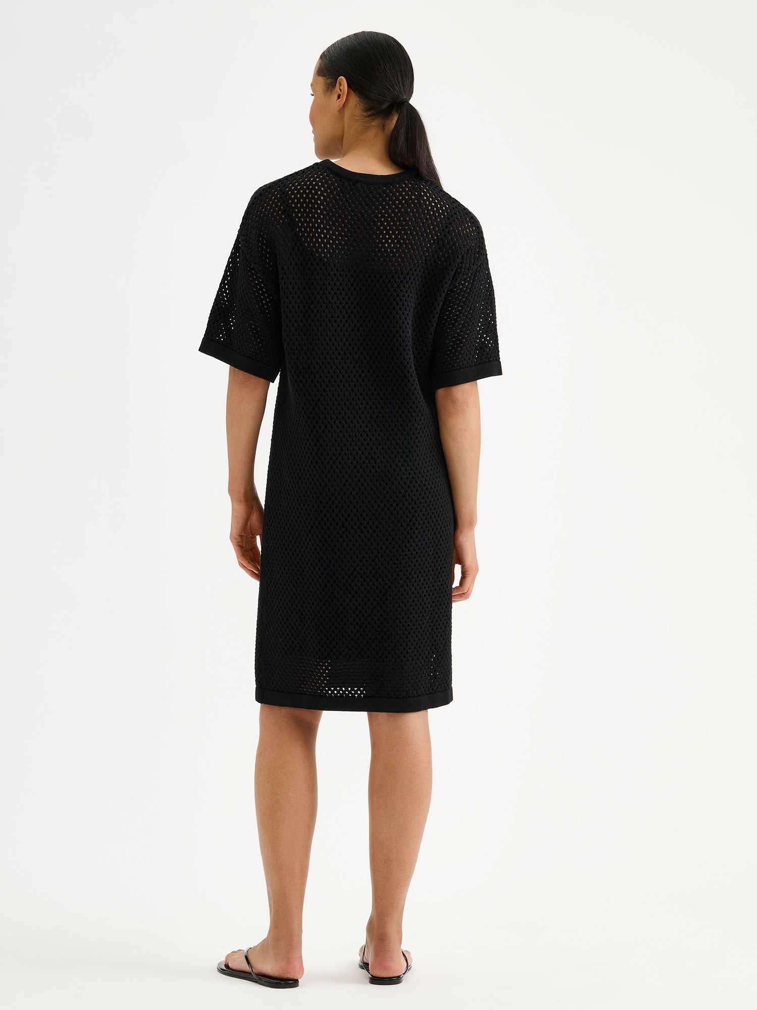 Nanson naisten trendikäs musta Aure -reikäneulemekko mallin päällä takaa kuvattuna.