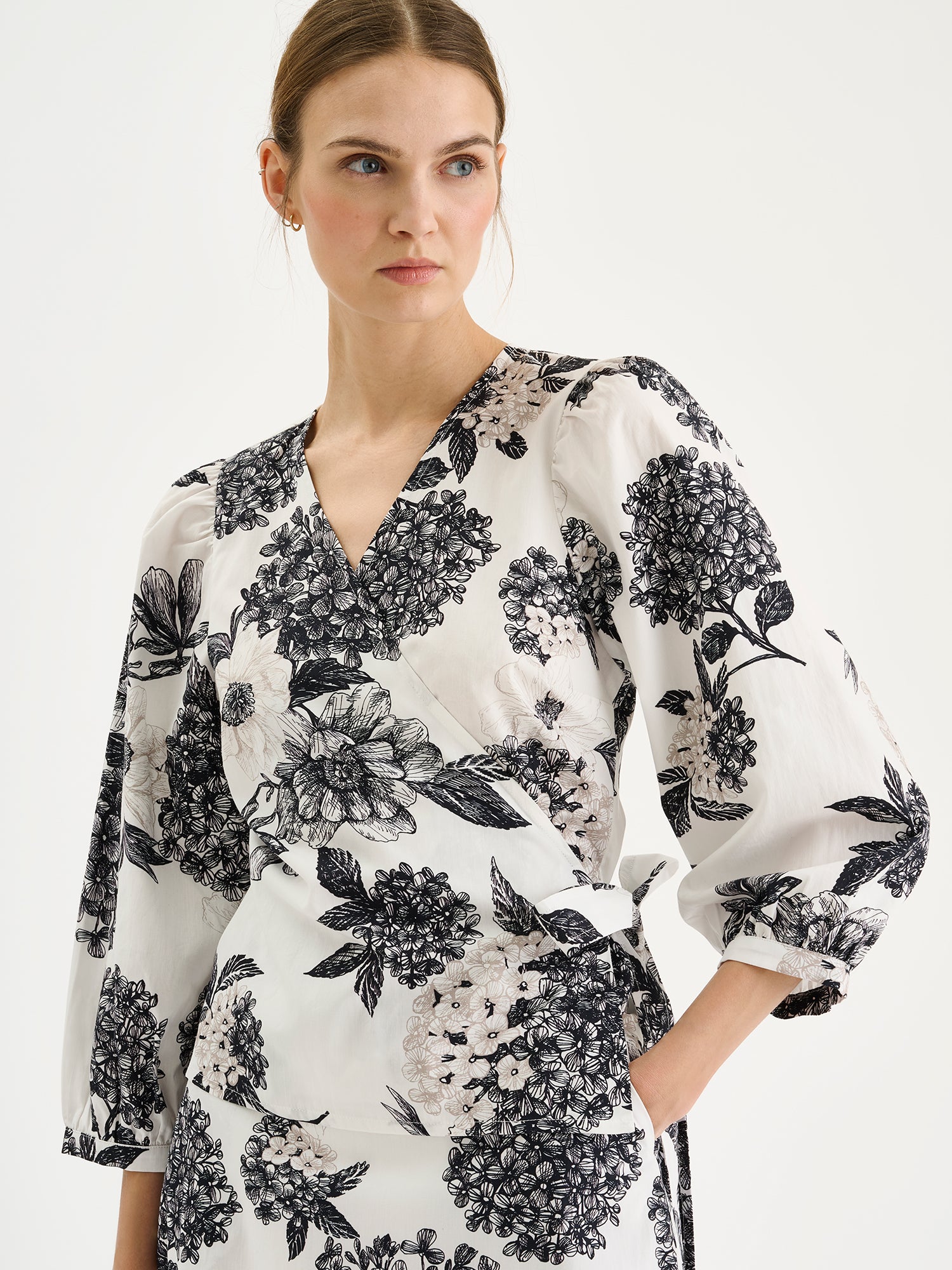 Nanson naisten hurmaava kuosillinen mustavalkoinen Palatsi-kietaisupusero mallin päällä saman sarjan hameen kanssa, lähikuvassa.