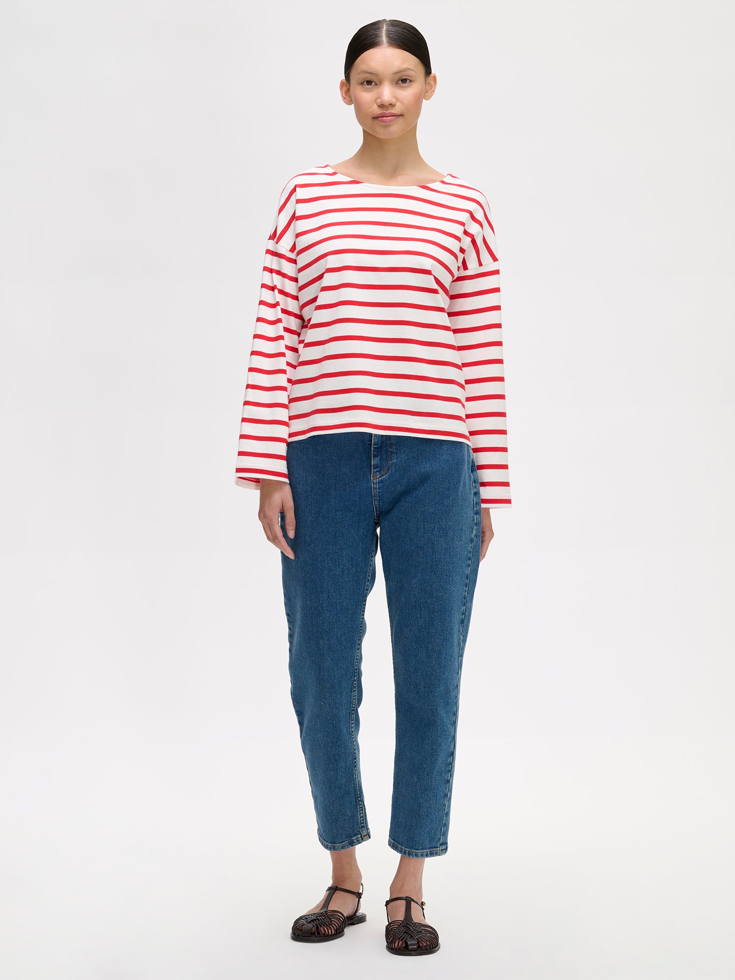 Naisten puna-valko-raidallinen ja ihanan rennon mallinen Breton-pusero mallin päällä farkkujen kanssa.