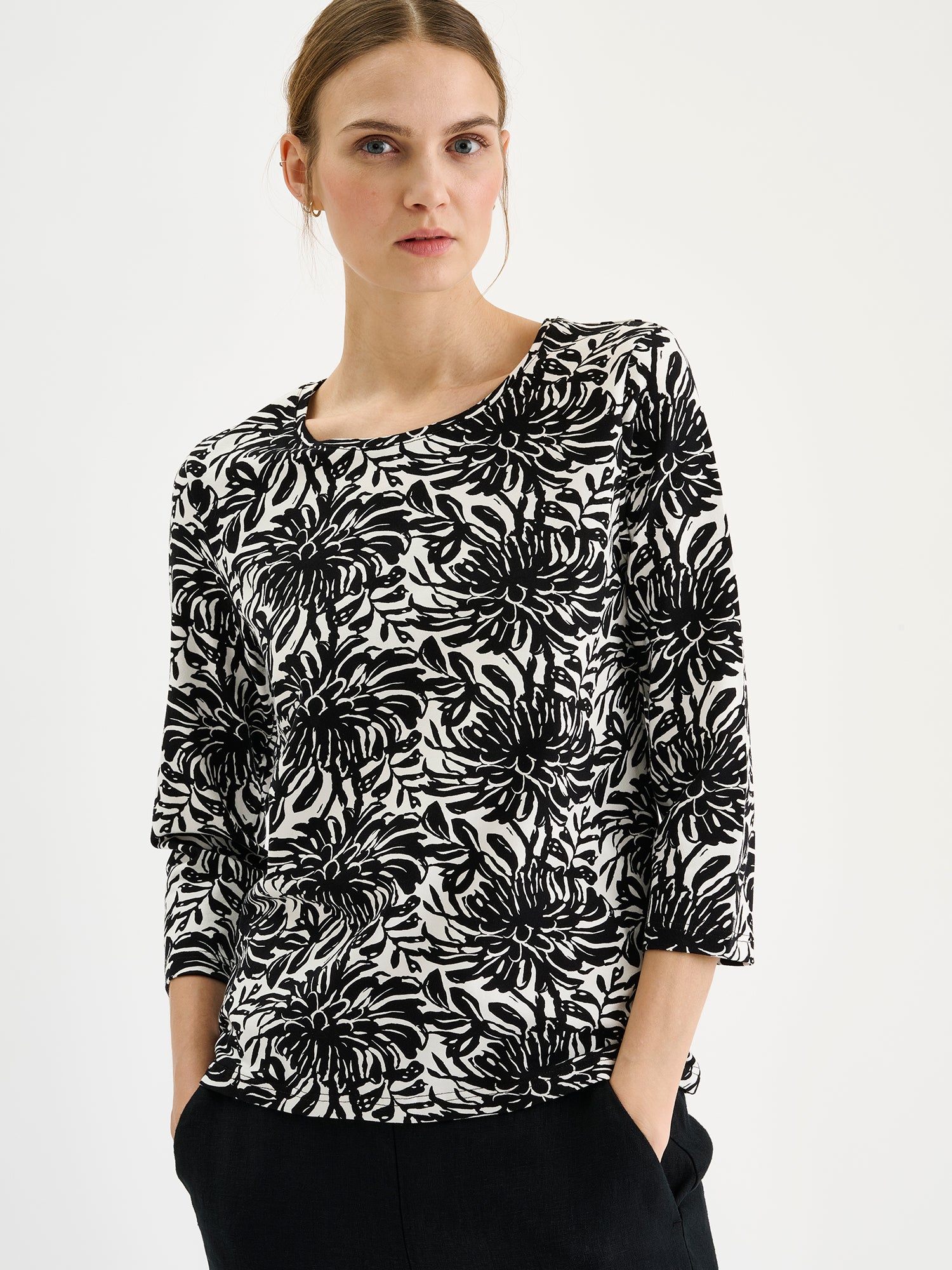 Nanson naisten kuosillinen mustavalkoinen Safiiri-trikoopusero mallin päällä mustien housujen kanssa lähikuvassa.