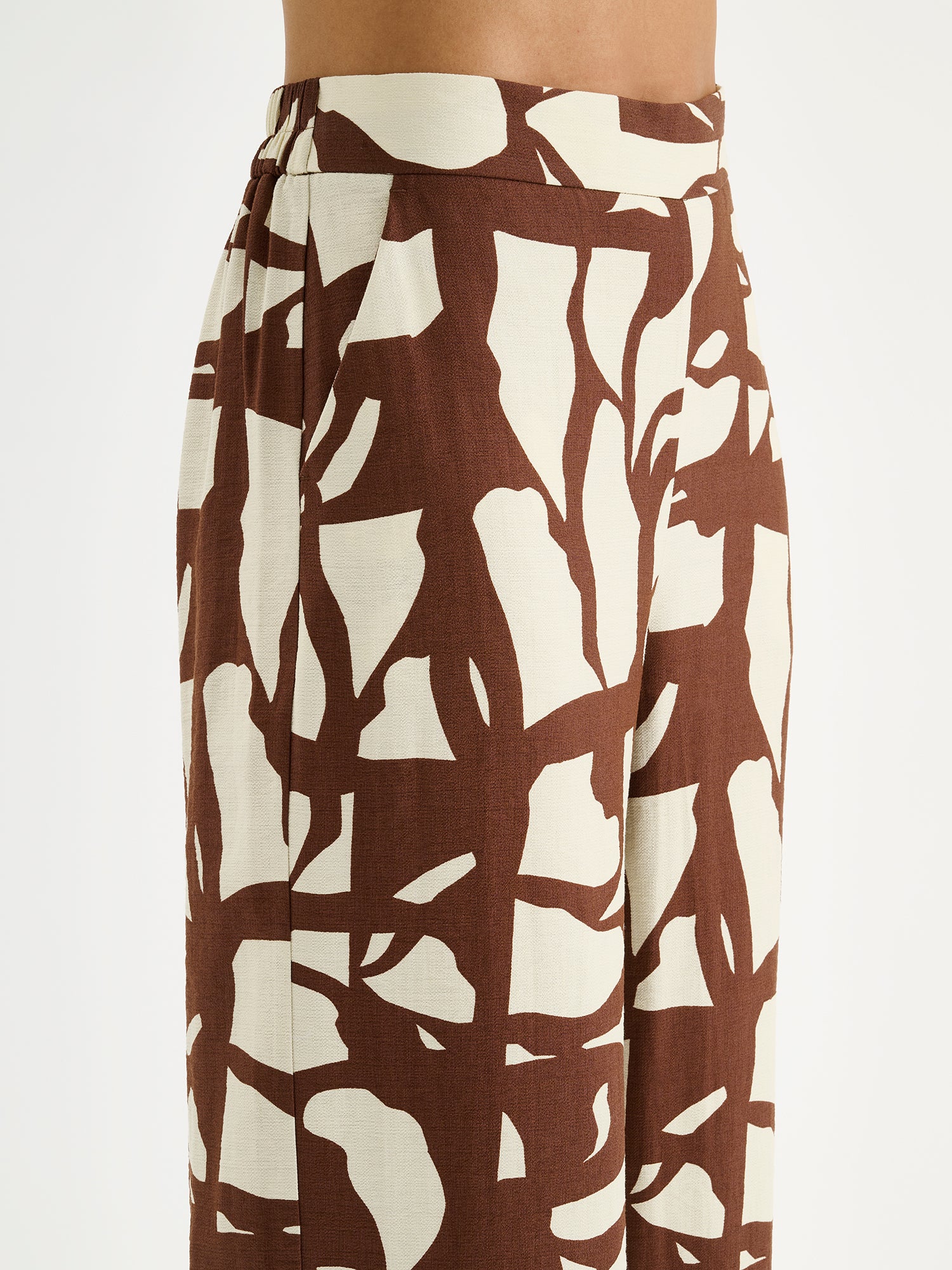 Nanson naisten ihanan rennot ja leveälahkeiset Palsta-housut sivutaskuilla ja tyylikkäällä kaksisävyisellä kuosilla mallin päällä lähikuvassa.