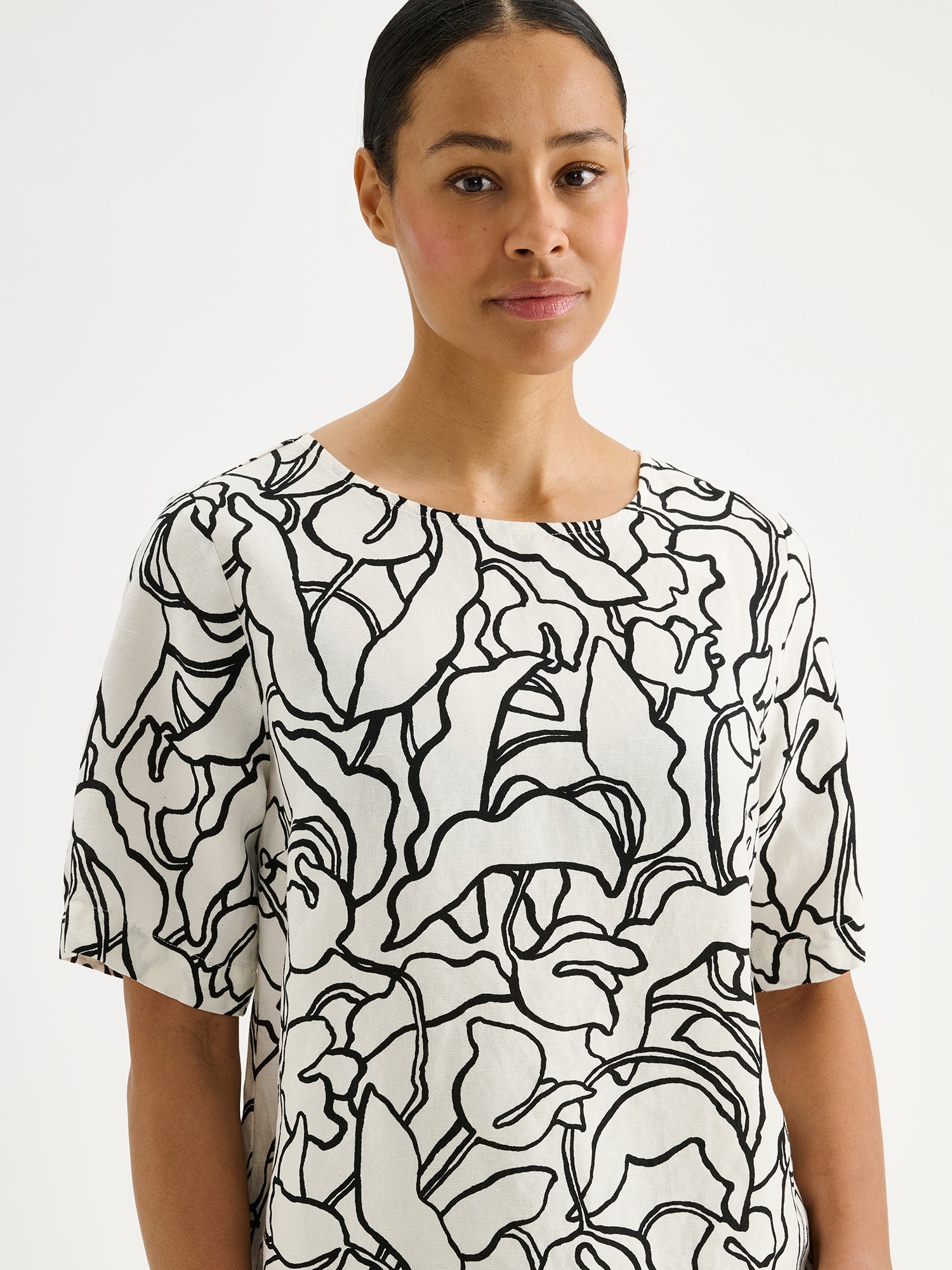 Nanson naisten tyylikäs ja ihanan rennon mallinen Iiris-pusero puolipitkillä hihoilla ja tyylikkäällä mustavalkoisella kukkakuosilla mallin päällä lähikuvassa