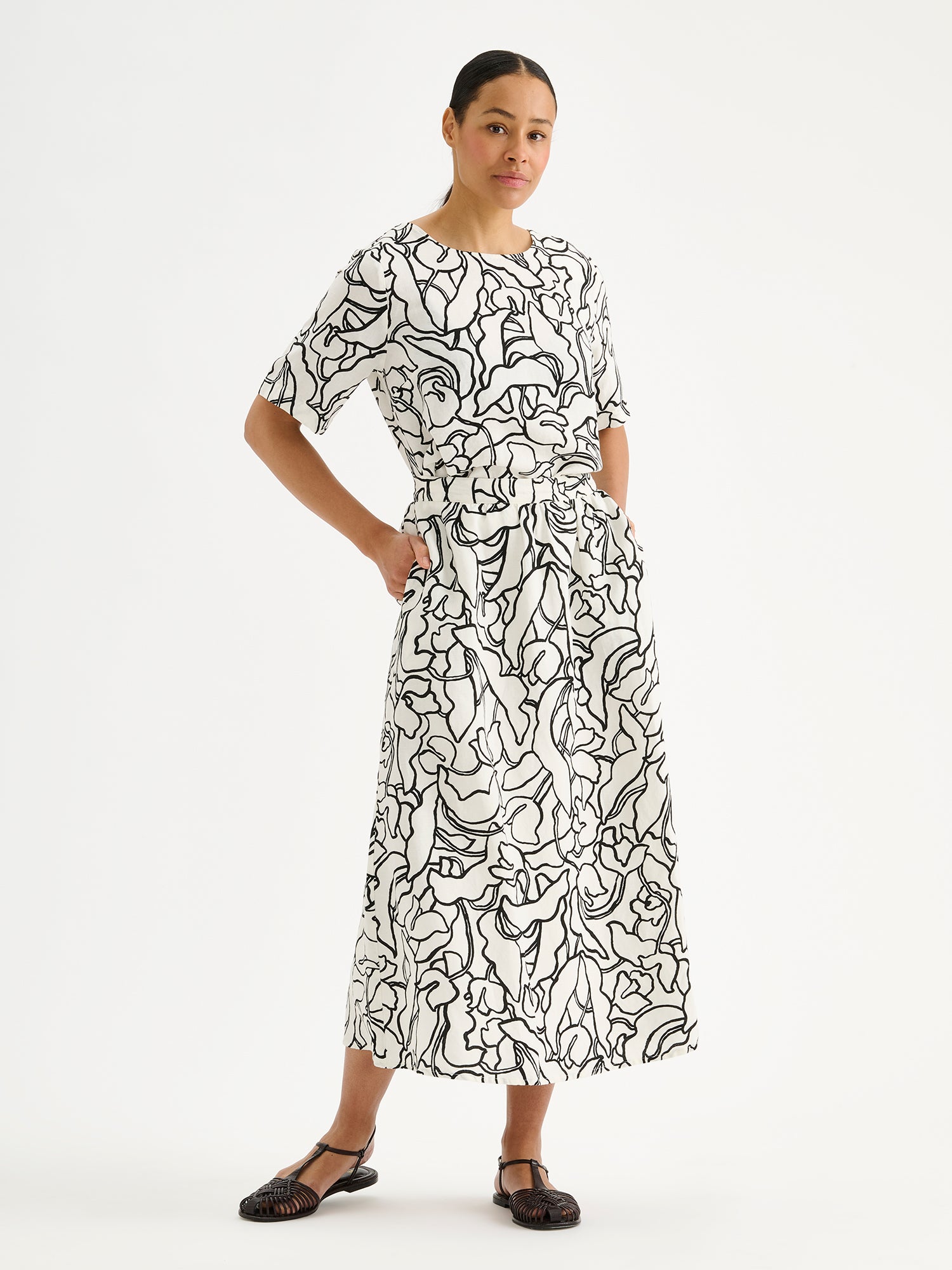 Nanson naisten tyylikäs ja ihanan rennon mallinen Iiris-pusero puolipitkillä hihoilla ja tyylikkäällä mustavalkoisella kukkakuosilla mallin päällä saman sarjan hameen kanssa.