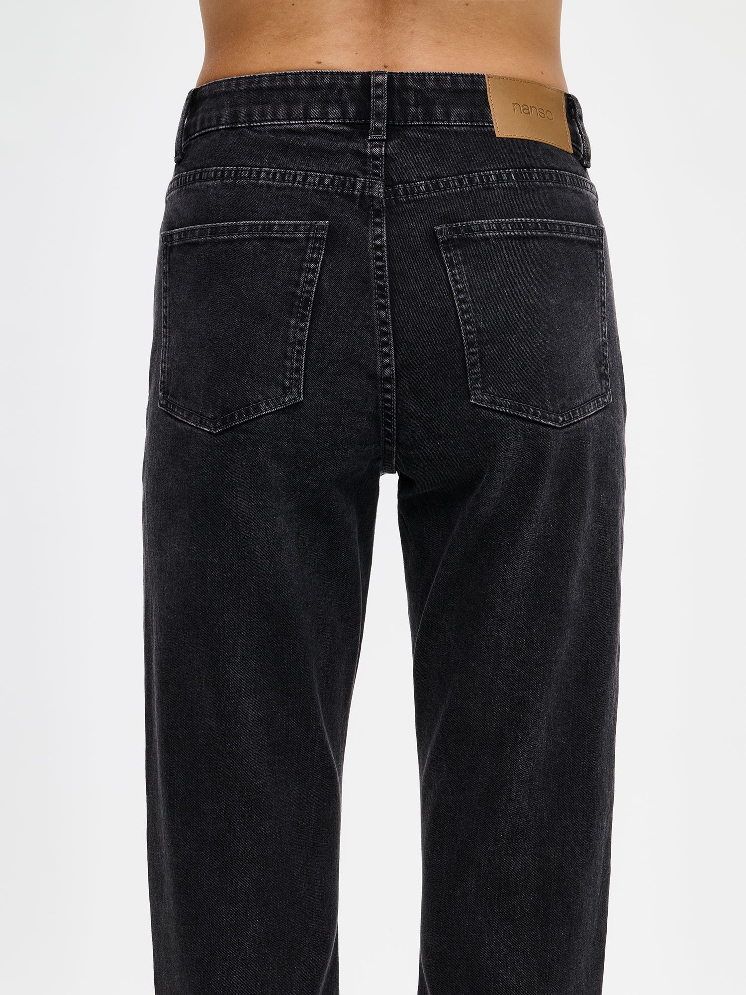 Naisten kapealahkeiset Cropped Kapee-farkut normaalikorkuisella vyötäröllä. Farkuissa on hieman kapenevat ja cropatut lahkeet. Valokuvassa mallin päällä takaa läheltä kuvattuna.