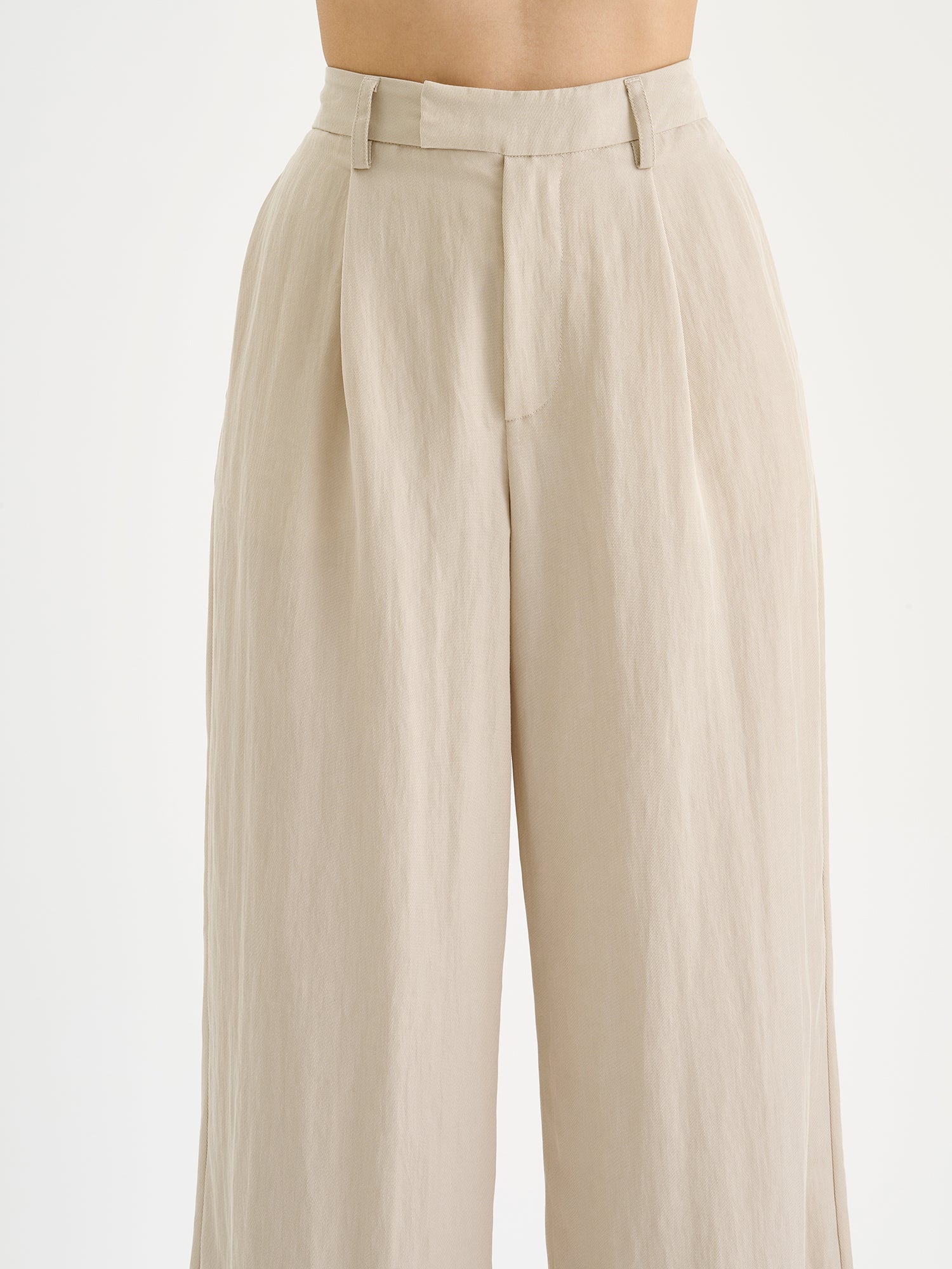 Nanson naisten beiget tyylikkäät Nizza-housut leveillä lahkeilla mallin päällä lähikuvassa.