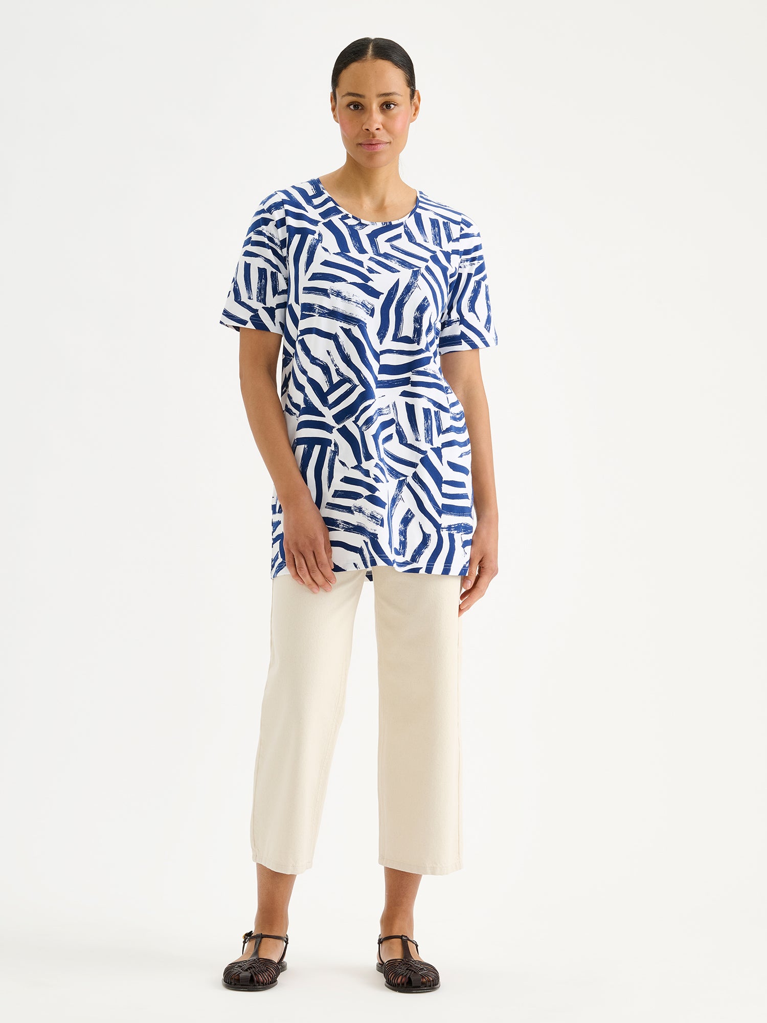 Nanson naisten laadukas kuviollinen Seilori-tunika, jossa on raikas sinivalkoinen kuosi mallin päällä vaaleiden farkkujen kanssa.
