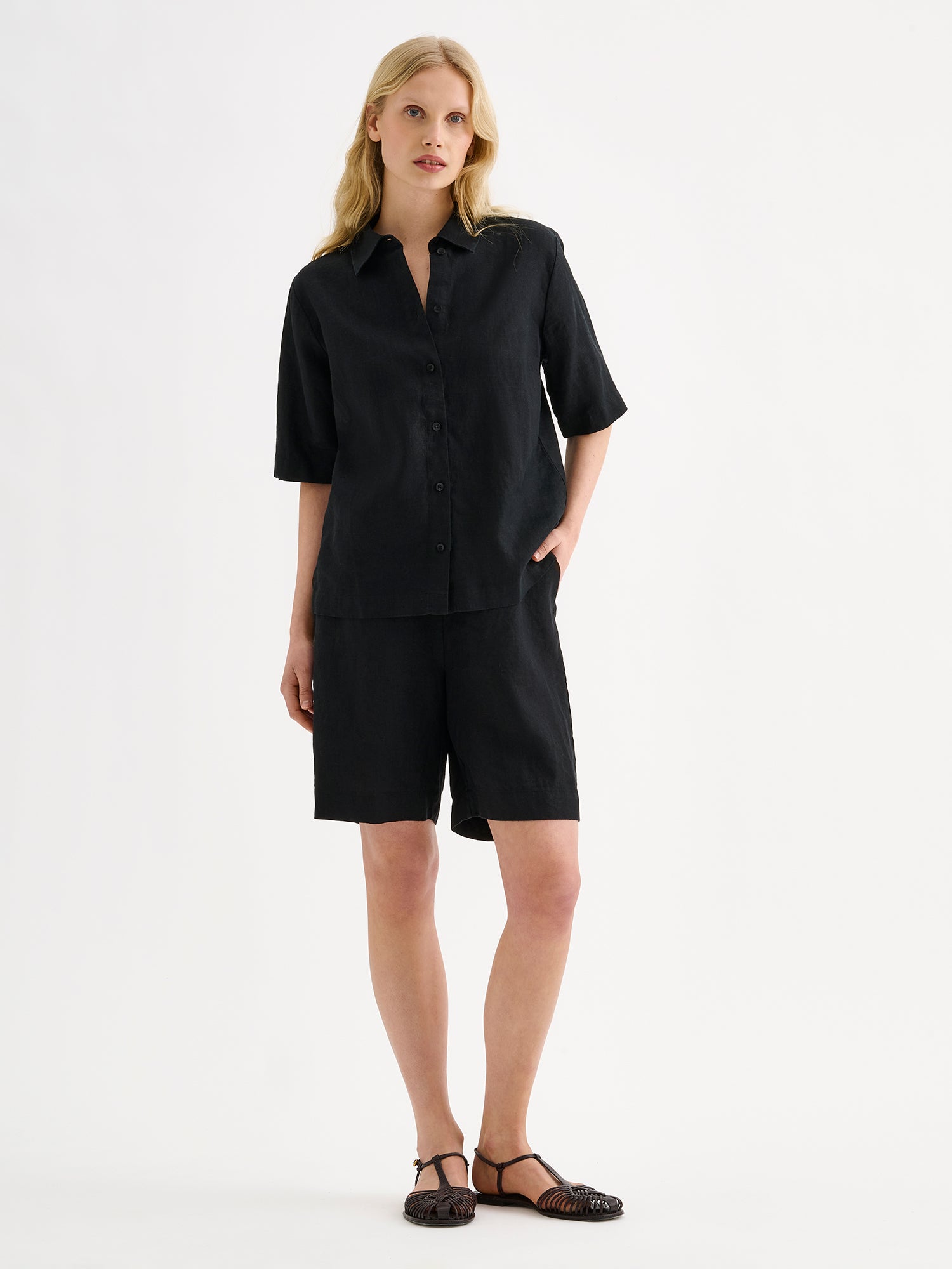 Nanson naisten klassiset mustat Liine-pellavashortsit ja paitapusero mallin päällä