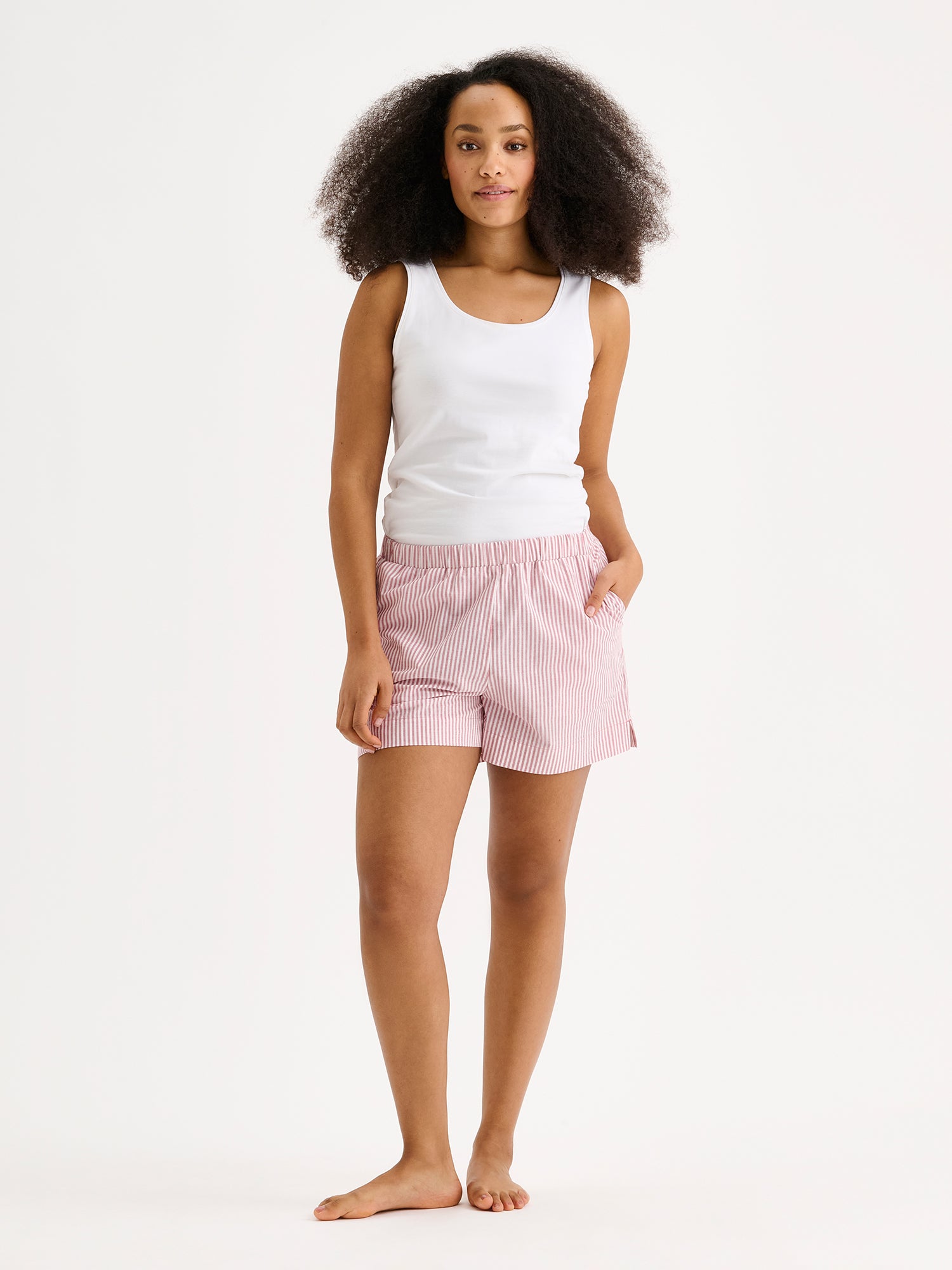 Naisten tyylikkäät, ihanan kevyet ja mukavat raidalliset Tauko-shortsit mallin päällä valkoisen topin kanssa.