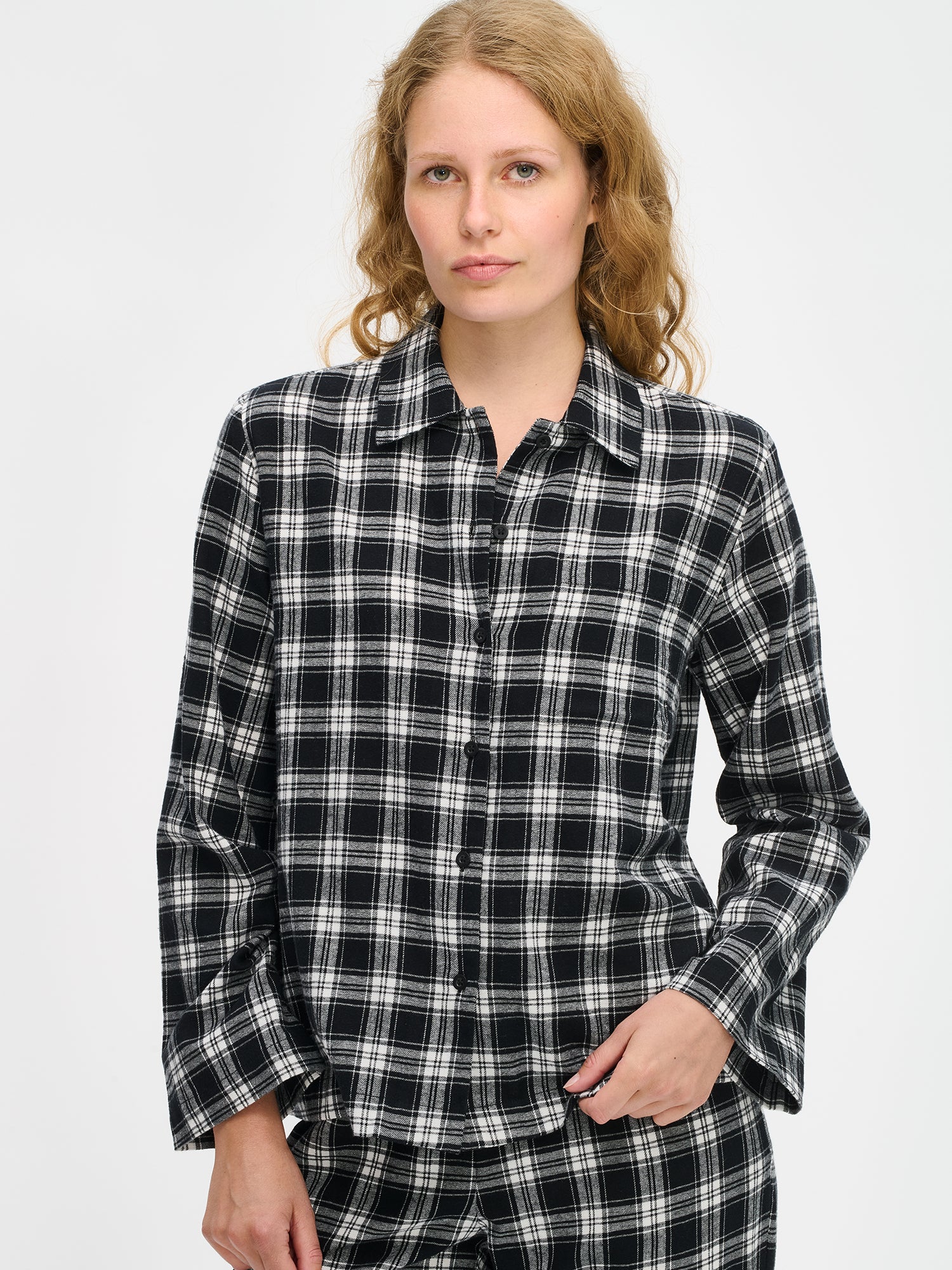 Nanson naisten mustavalkoinen ruutukuosinen flanellipaita mallin yllä lähikuvassa, lantiolle ulottuva, kaulus, nappilista ja rintatasku pehmeässä puuvillaflanellikankaassa.